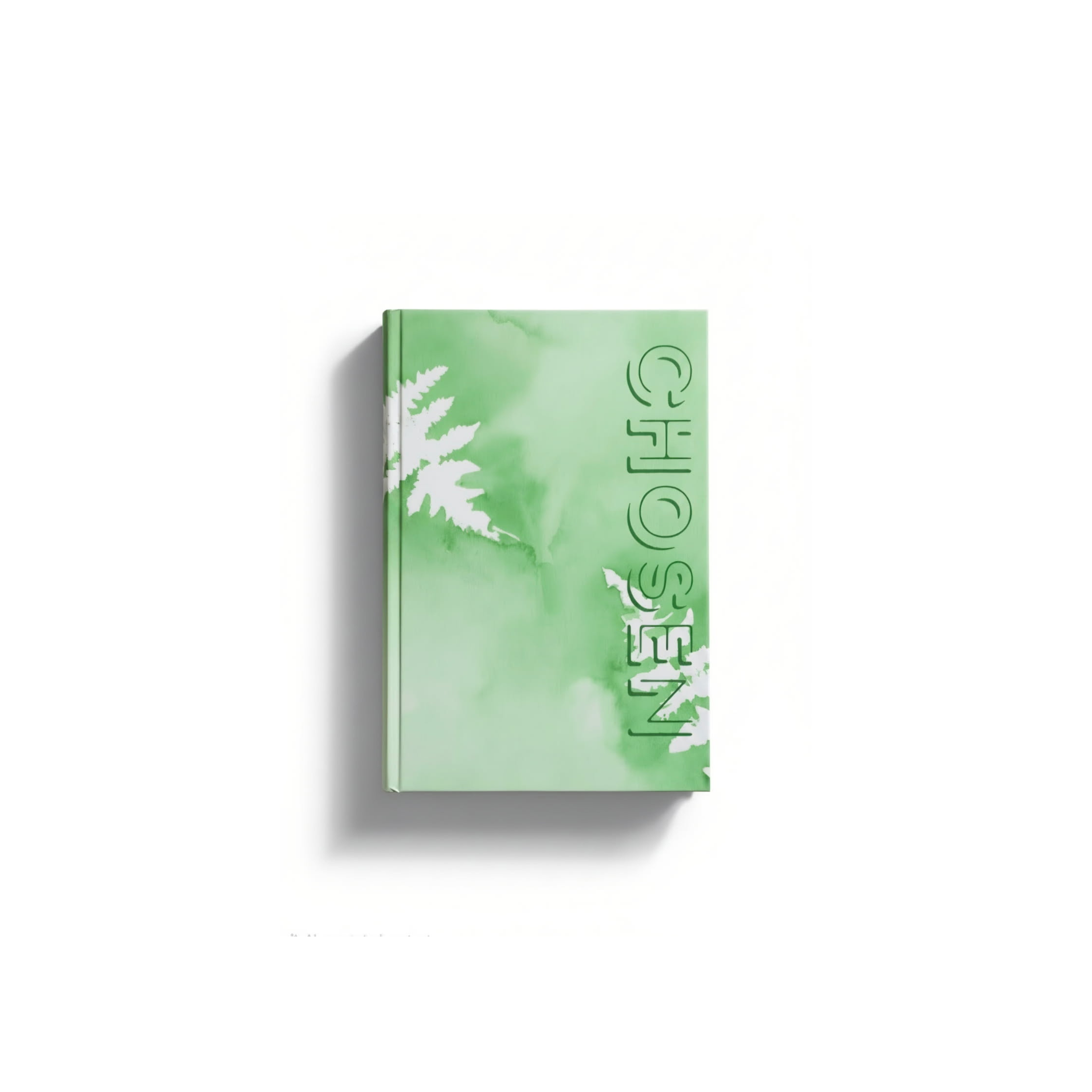 Close-up of a green-colored book with illustrations of fern leaves and partially visible text on a white background.