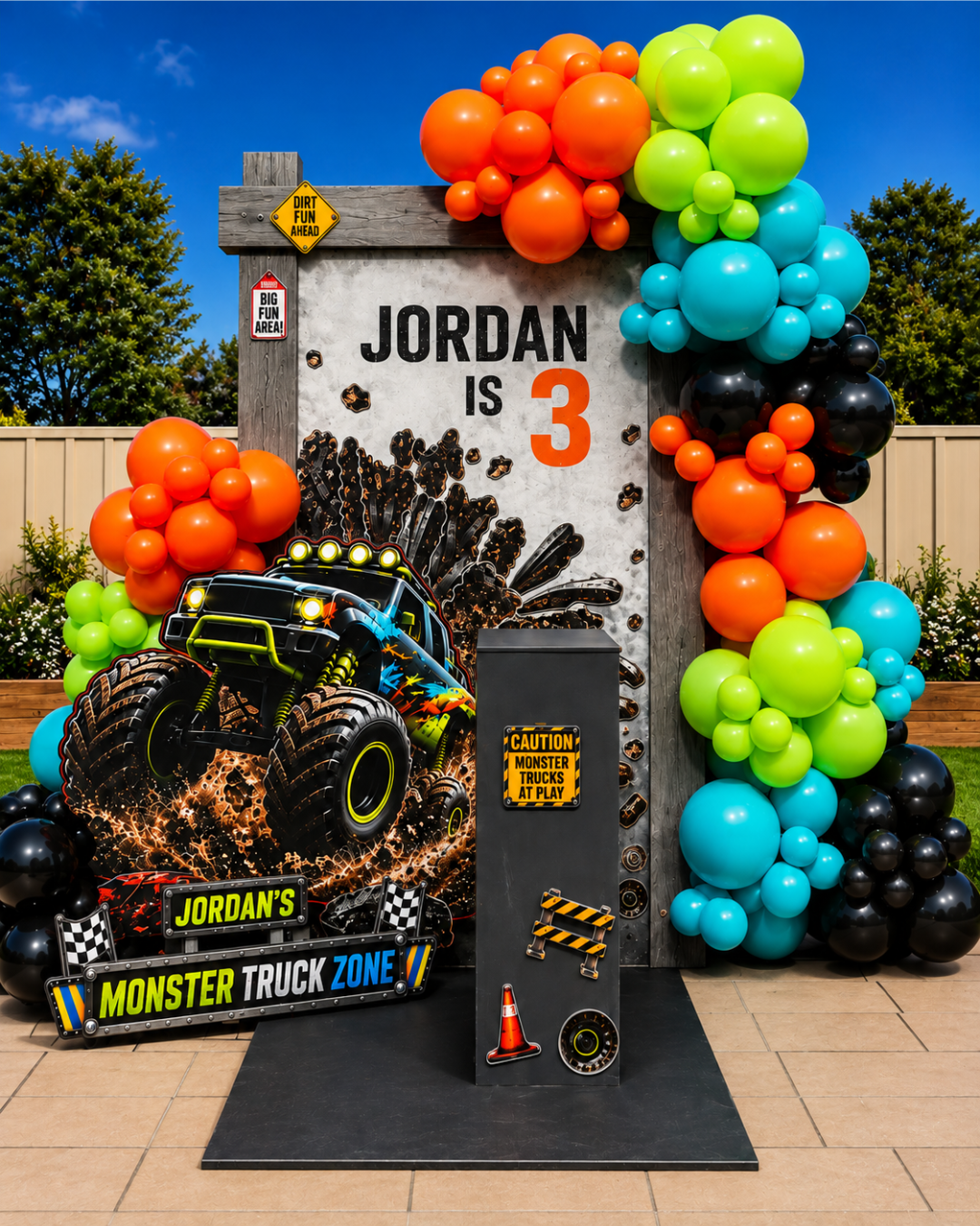 Monster truck themed birthday party setup with colourful balloons, decorations and a “Jordan is 3” sign.