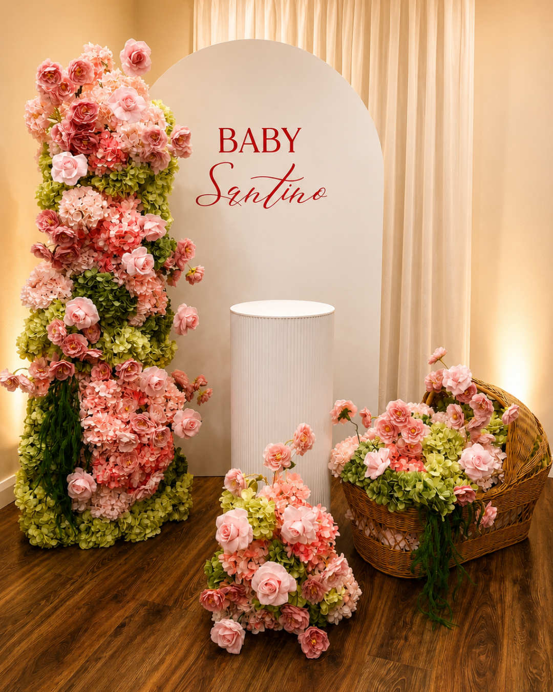 Decorative floral display with pink and green flowers around a sign that reads "Baby Santino."