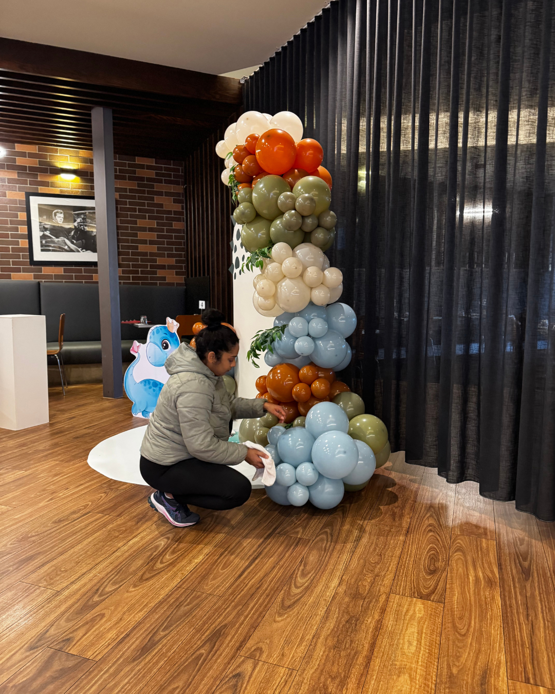 Balloon installation featuring a colourful balloon column in orange, beige, green, blue and white, styled for an event in Melbourne.