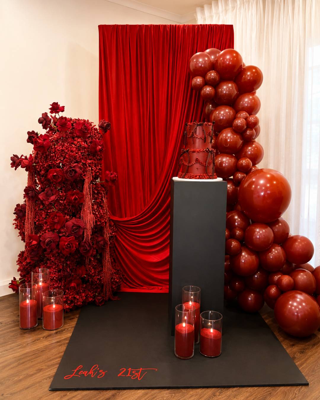 Red-themed 21st birthday display with roses, balloons, backdrop, birthday cake and personalised “Leah’s 21st” sign.