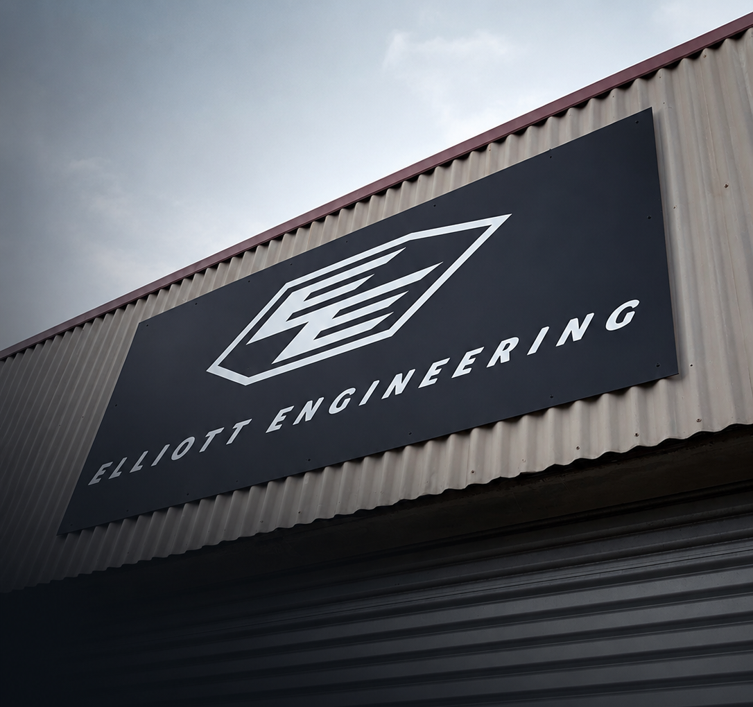 A sign on the outside of a building displays 'Elliott Engineering' with a geometric logo above the name.