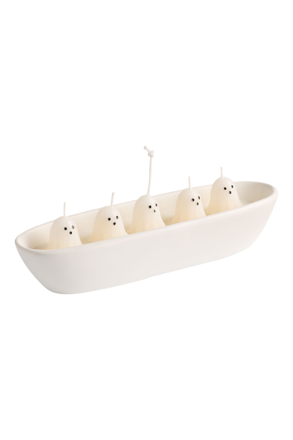 White boat-shaped candle holder with five ghost-shaped white candles, each with small black dots for eyes, one candle taller with wick burnt out, set against a white background.