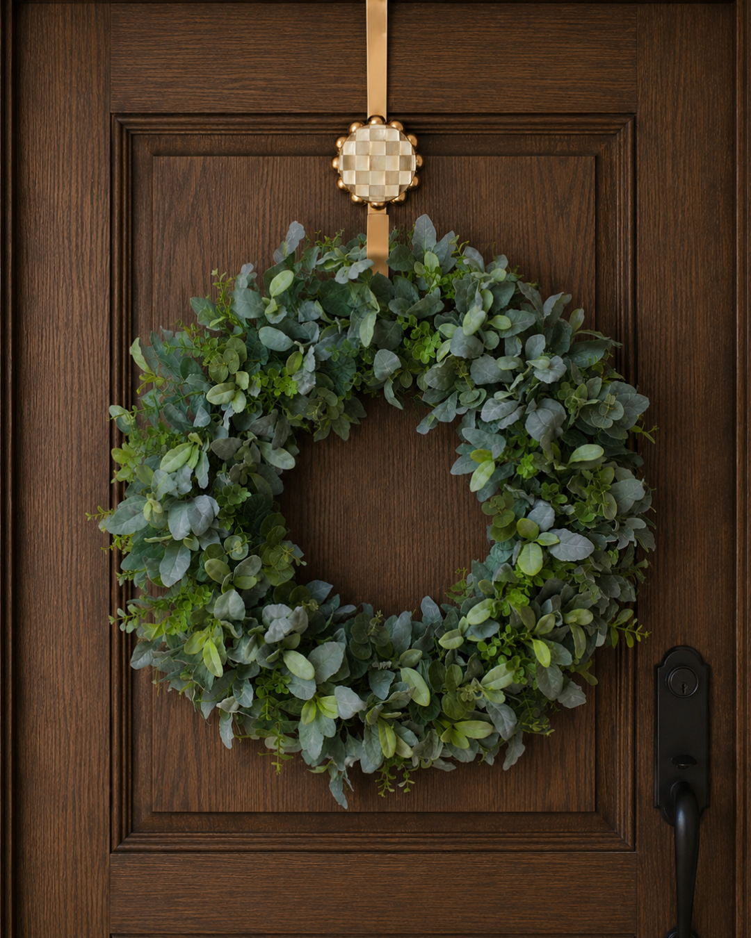 Decorative green wreath hanging on a wooden front door.