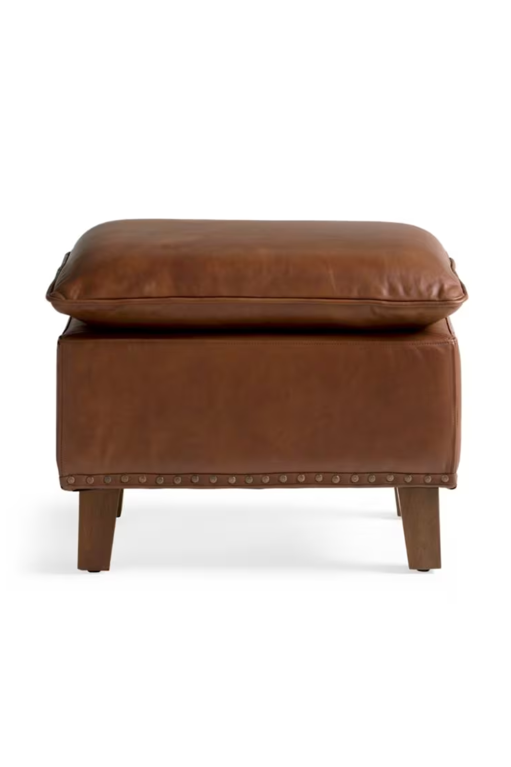 Brown leather ottoman with a cushion on top and wooden legs.