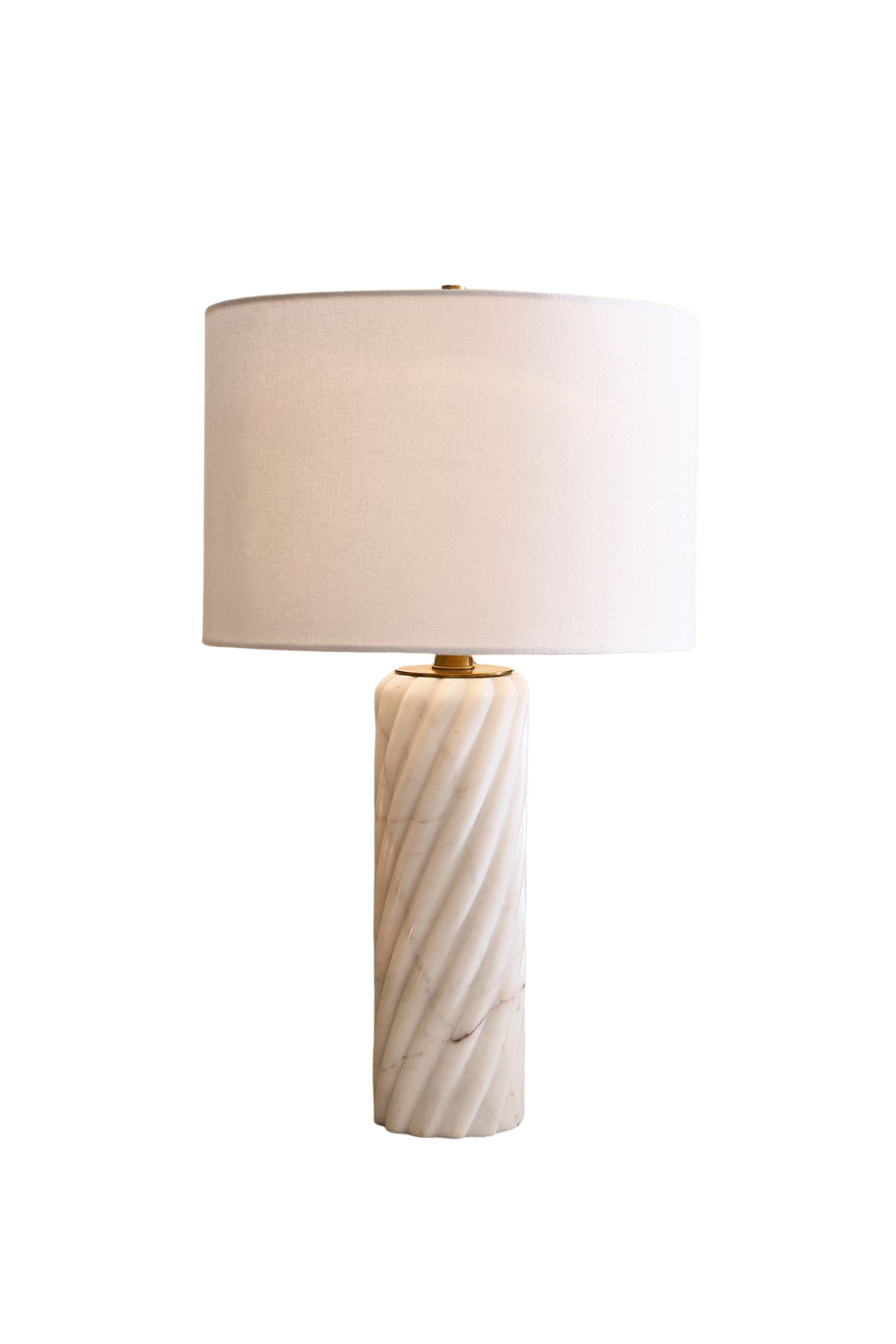 A table lamp with a carved white marble base and a large white fabric lampshade.