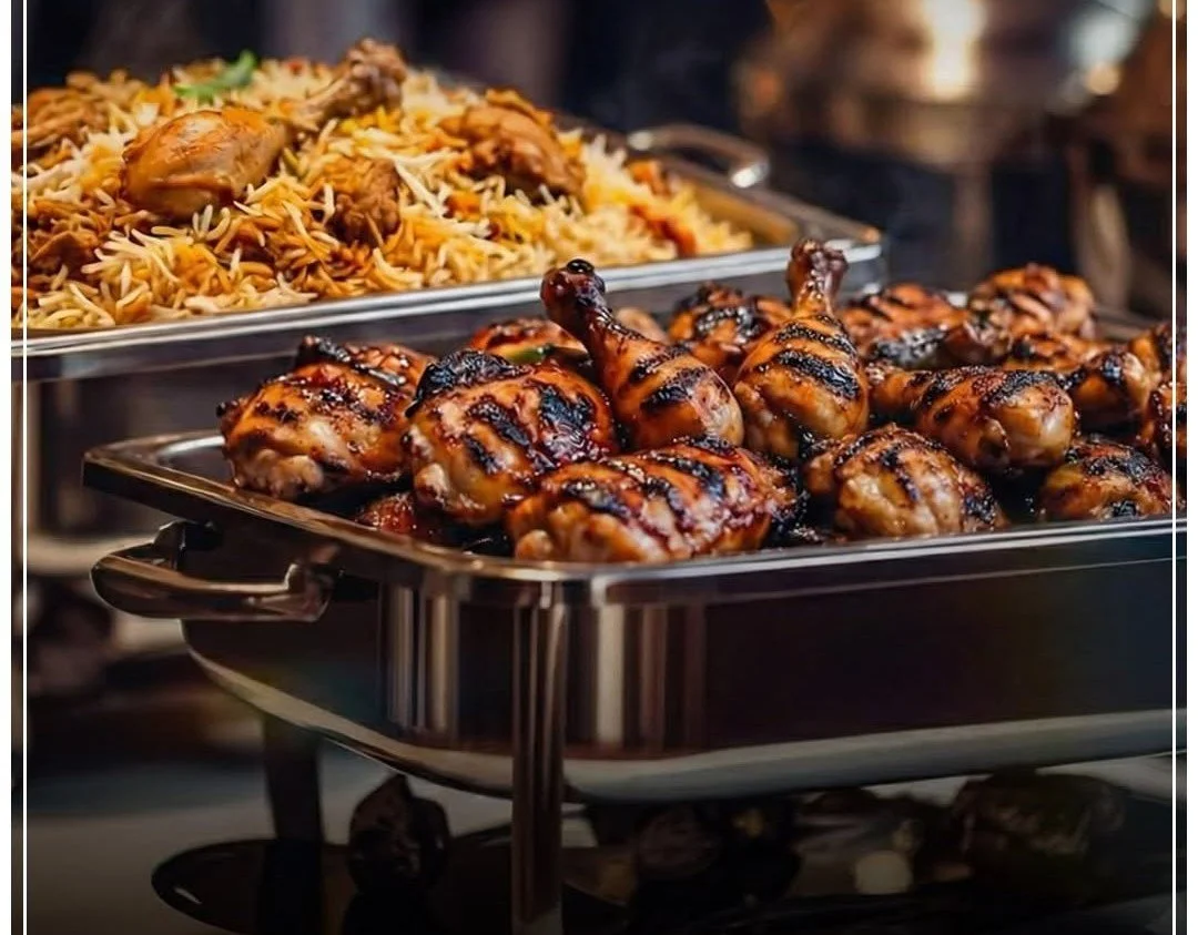 Buffet of grilled chicken drumsticks and rice with vegetables.