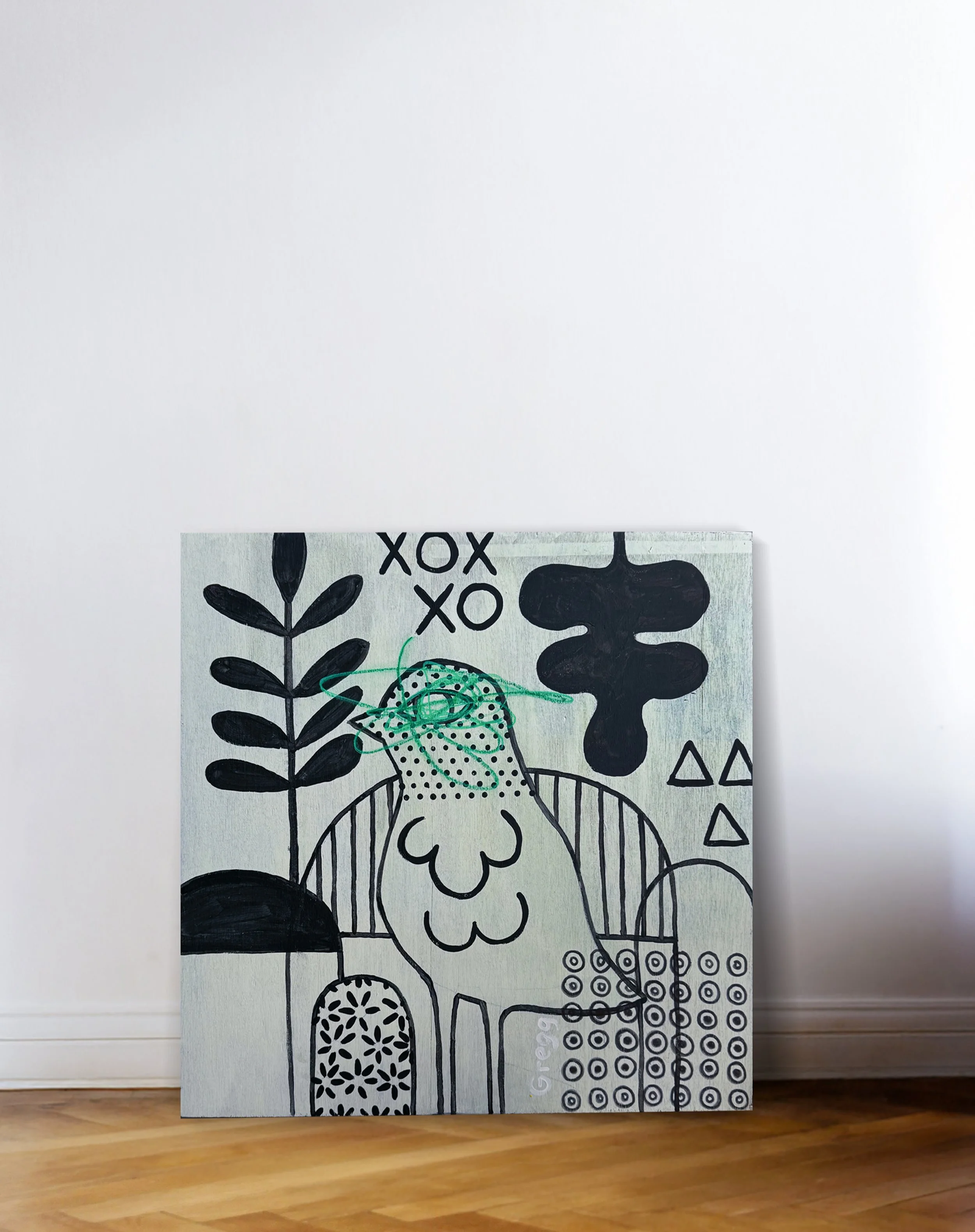 A large canvas with abstract black and white line art design, featuring various botanical and geometric patterns, leaning against a white wall on a wooden floor.