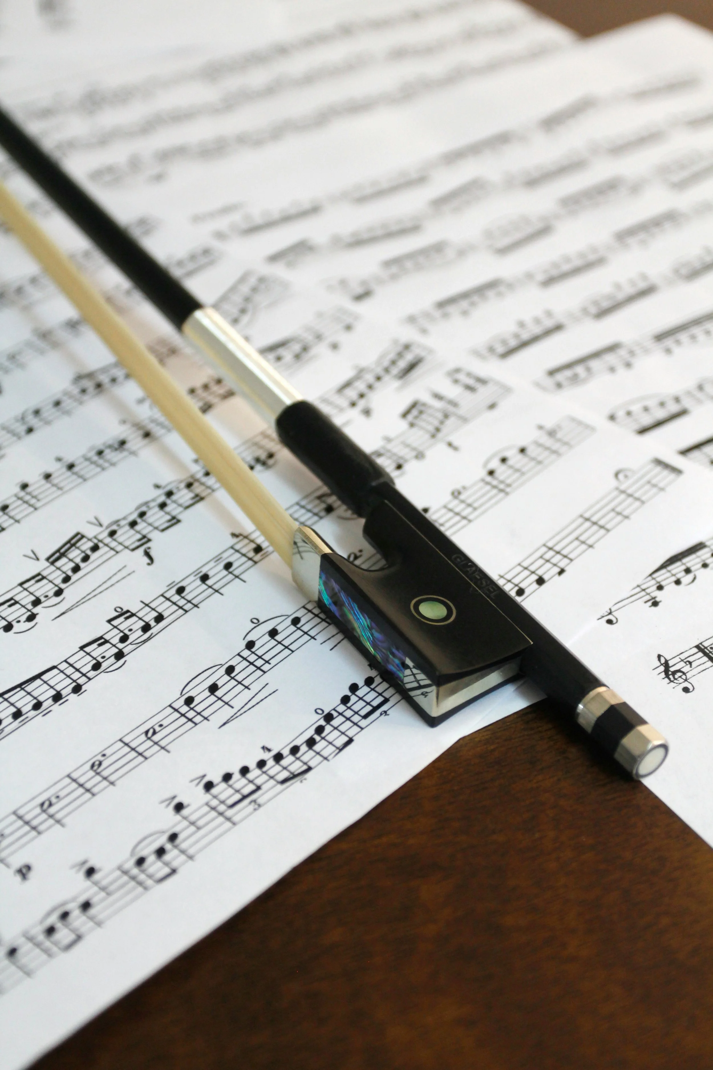 Violin bow resting on sheet music, representing thoughtful repertoire planning for private events, corporate gatherings, and live string music.