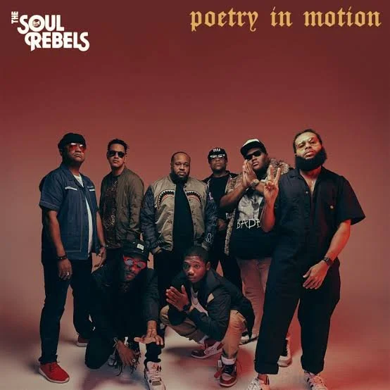 Six men standing and crouching in front of a reddish gradient background. The text reads 'Soul Rebels' in the top left corner and 'poetry in motion' in the top right corner.