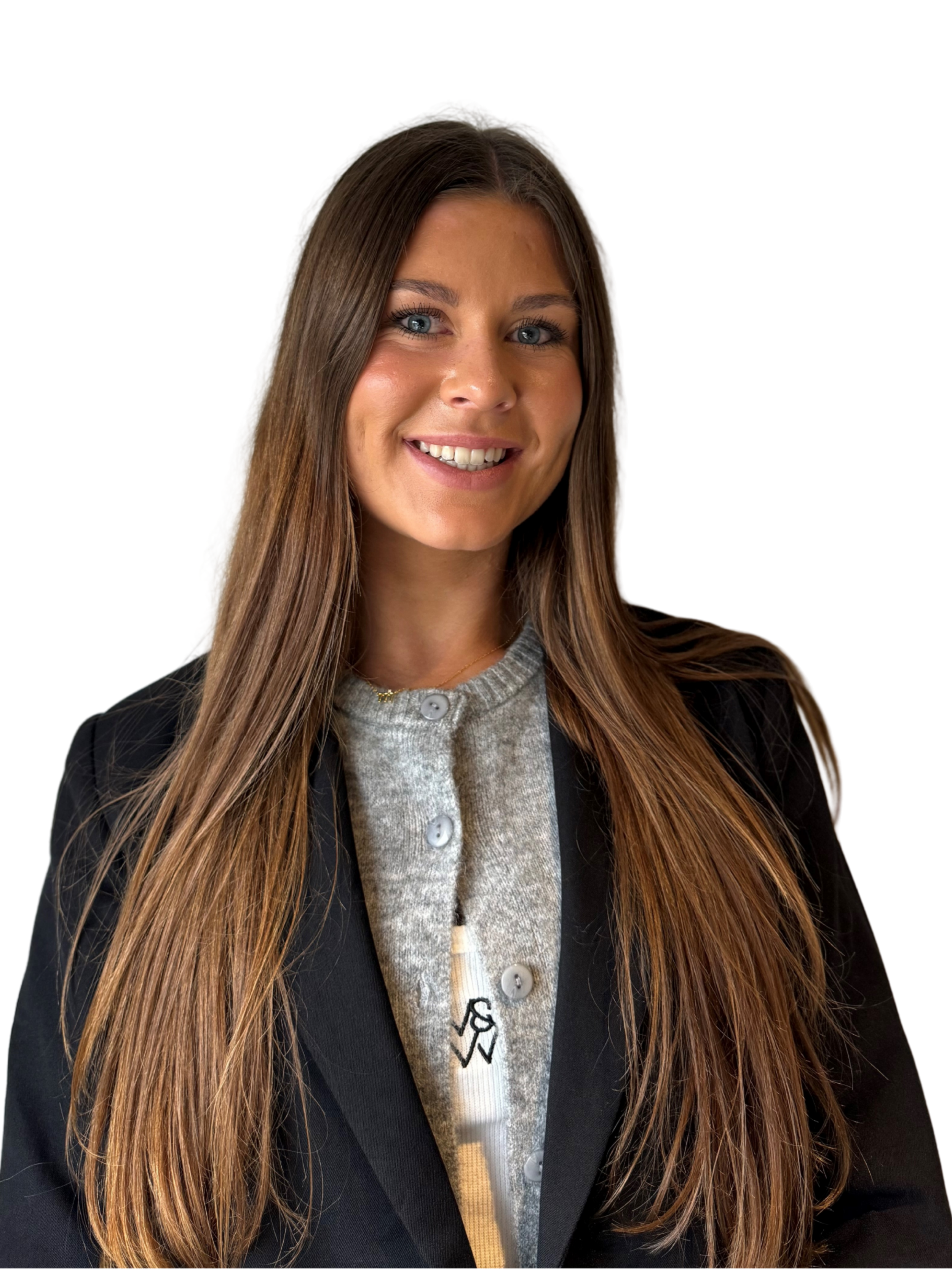 Portrait of a smiling woman with long brown hair, blue eyes, wearing a black blazer over a gray sweater with buttons, and a white shirt with a logo.
