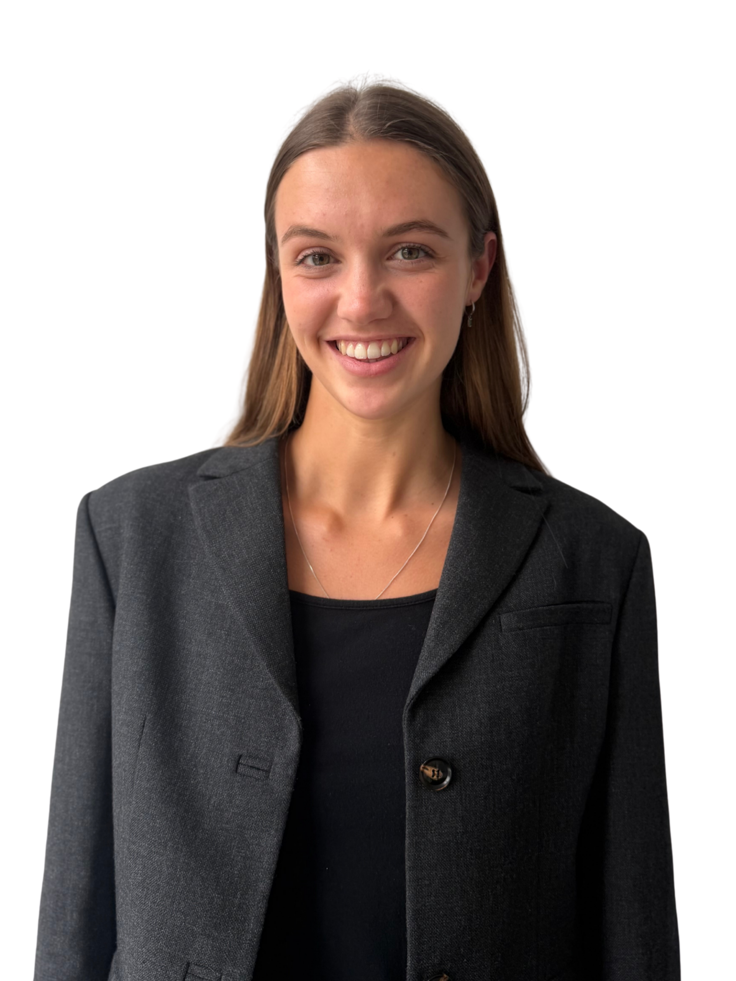 A woman with long brown hair, wearing a black blazer over a black top, smiling in front of a plain white background.