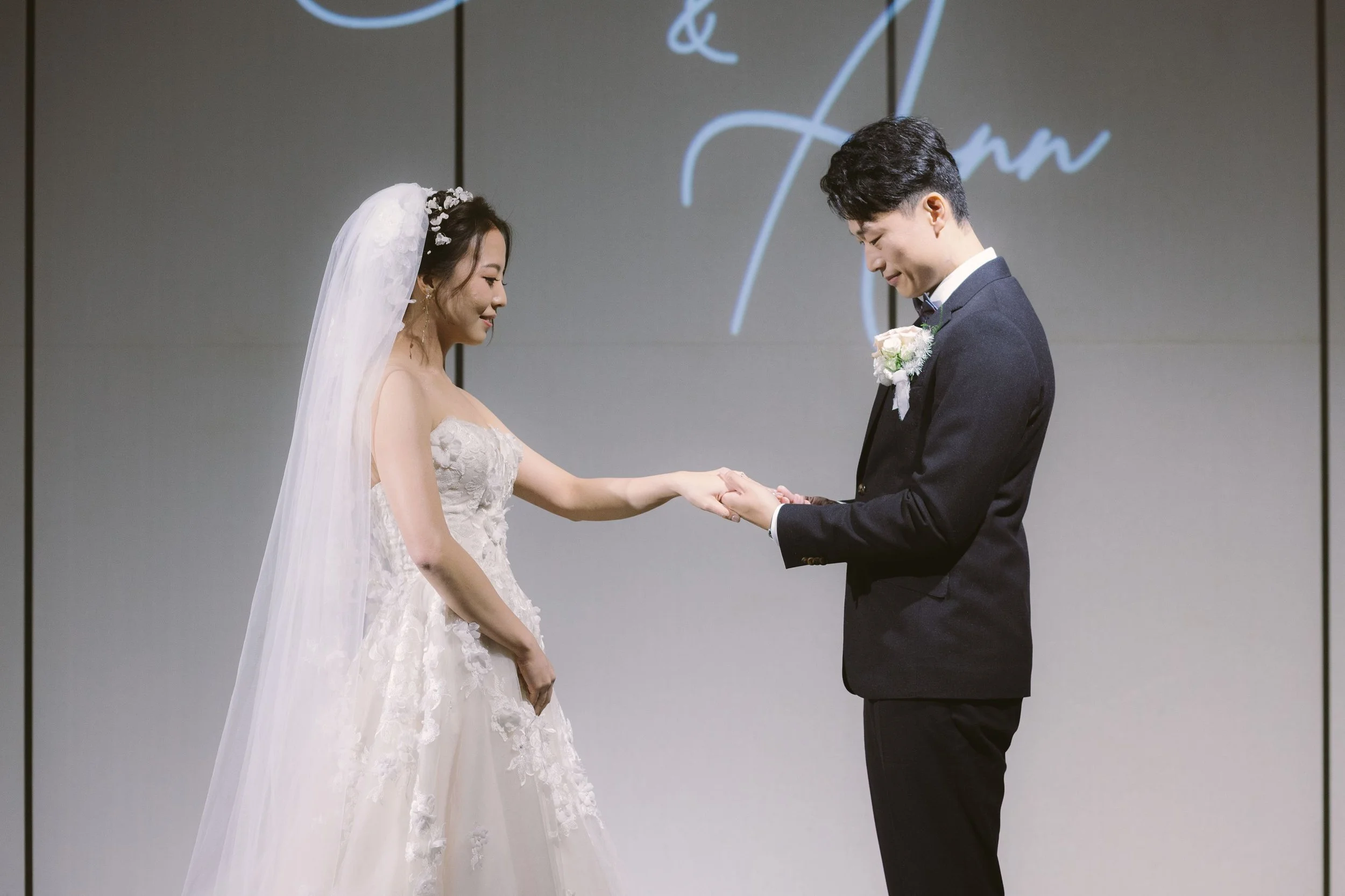 A bride and groom exchanging wedding vows, holding hands, during a wedding ceremony.