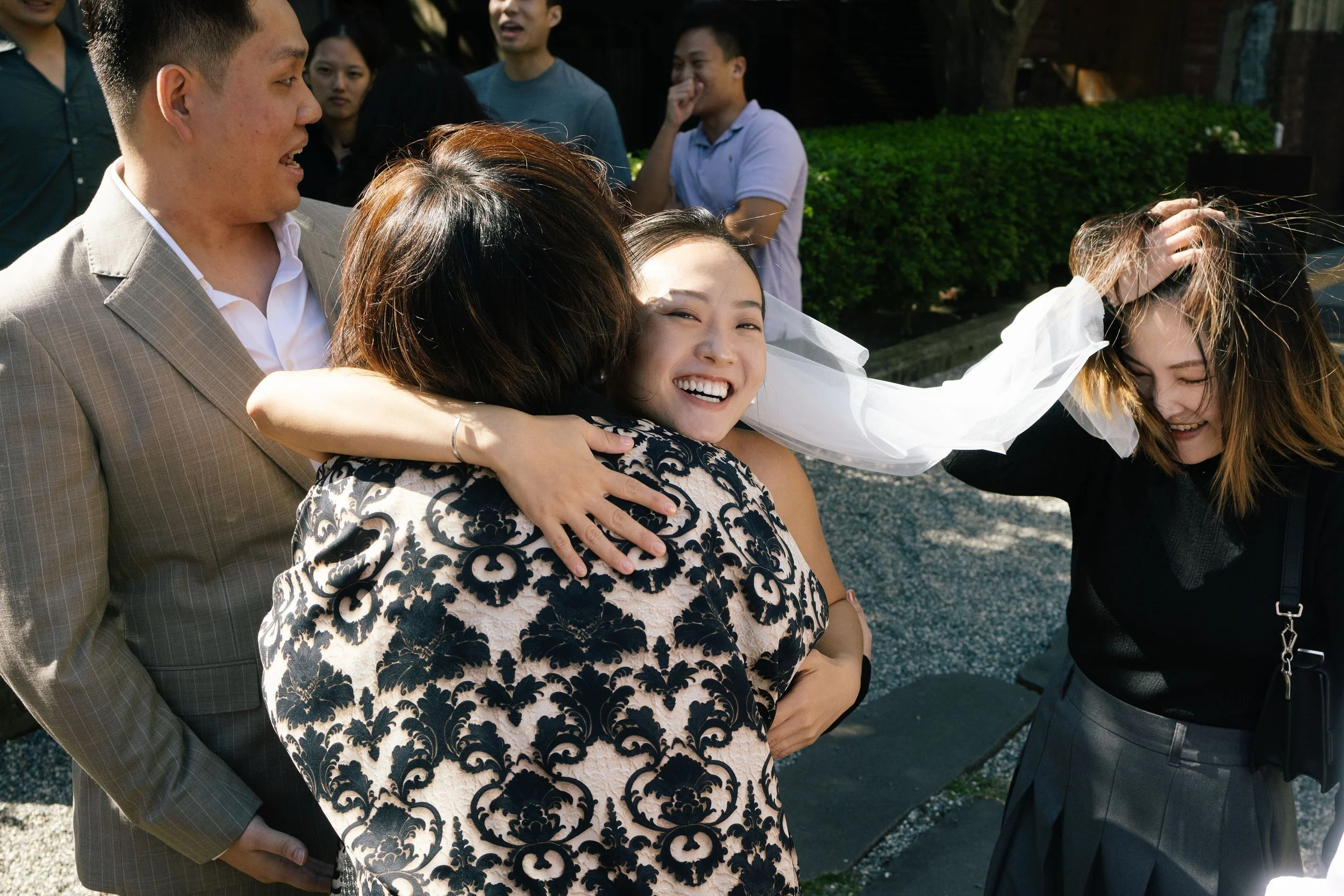 People gathered outside, smiling and hugging during what appears to be a joyful event or celebration.