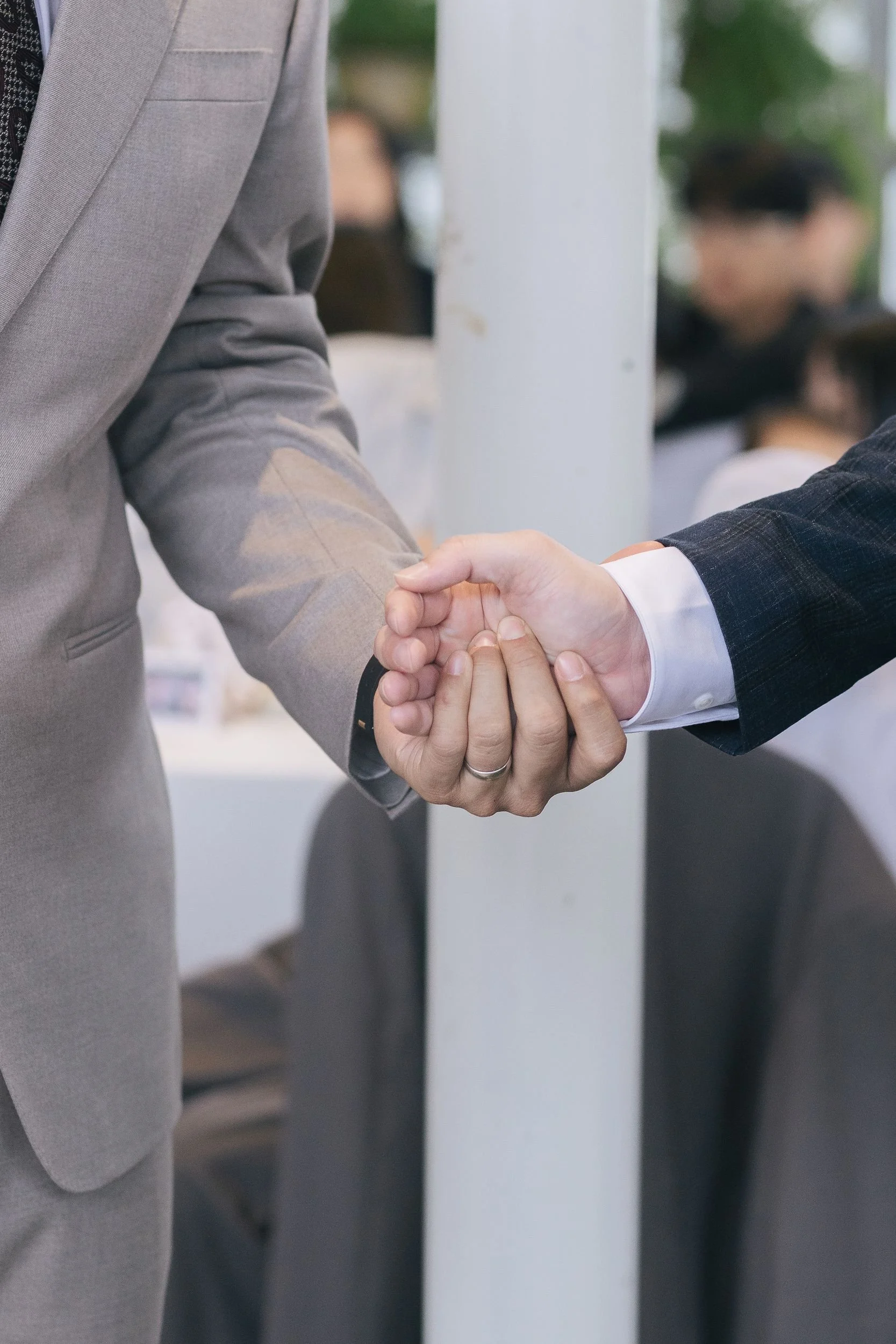 Two people in business suits shaking hands.