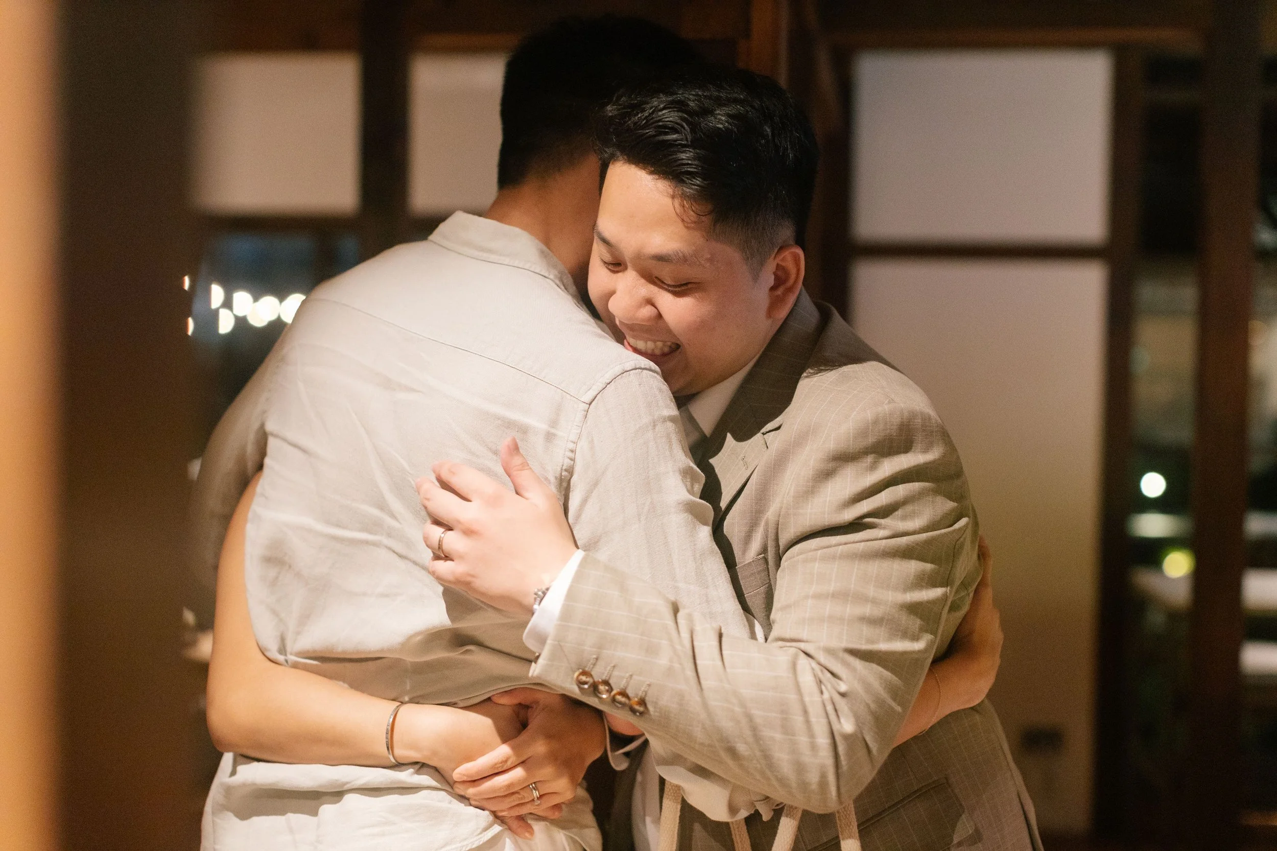 Two men are hugging warmly, smiling, and appear happy and emotional.
