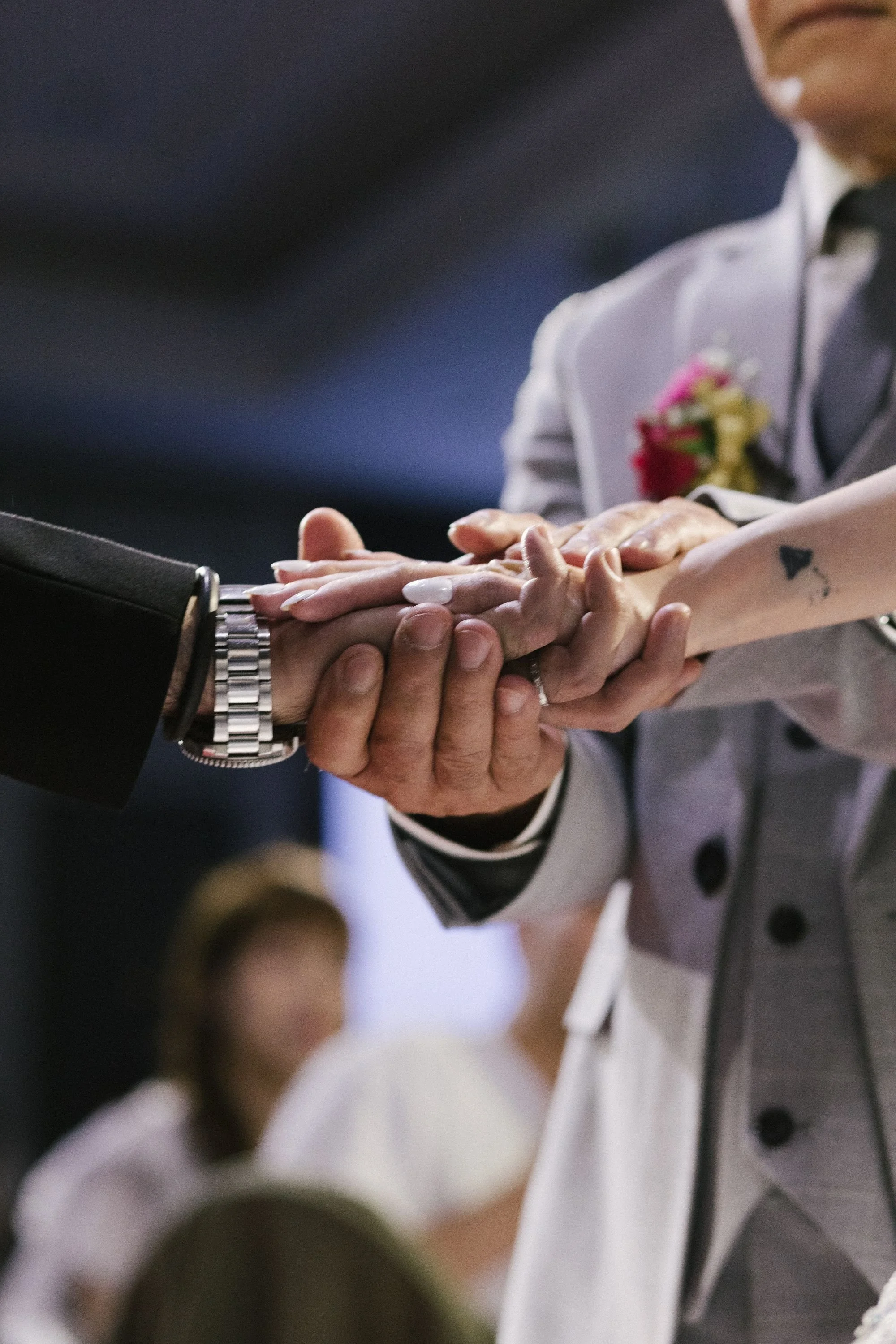 People in formal attire holding hands in a gesture of unity or celebration.