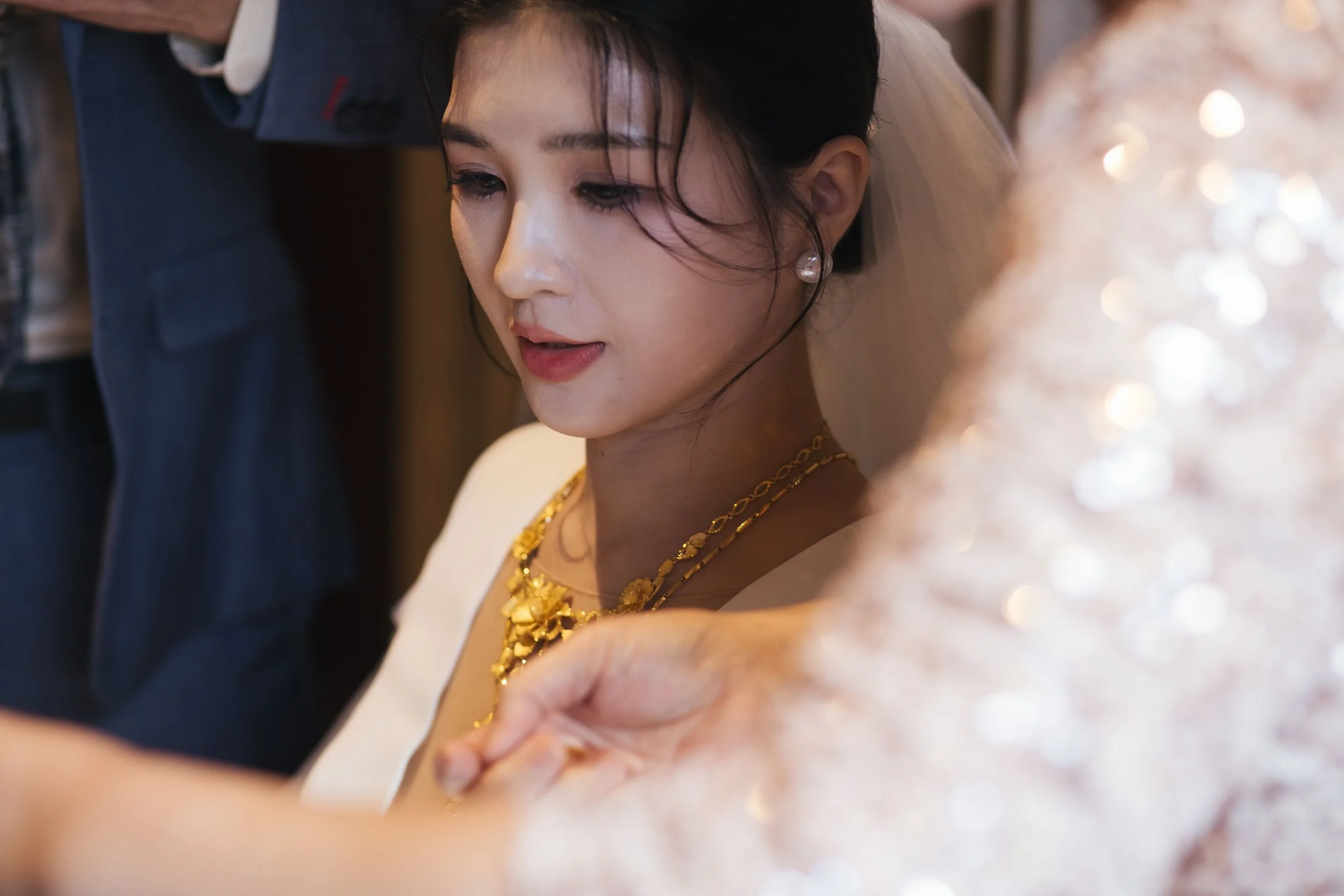 Close-up of a woman wearing golden jewelry, with a focus on her face and jewelry, during a special occasion.