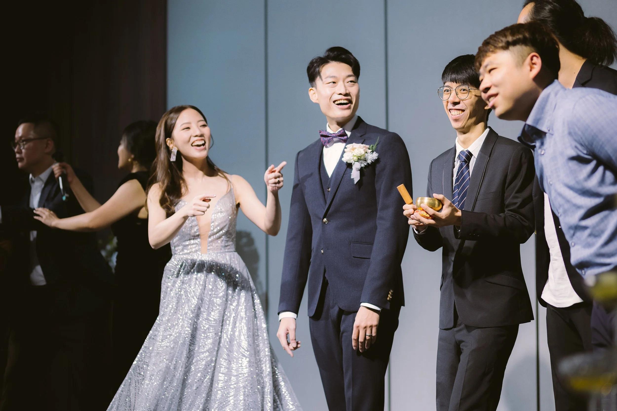 Group of people dressed in formal attire, smiling and talking at a social event or celebration.