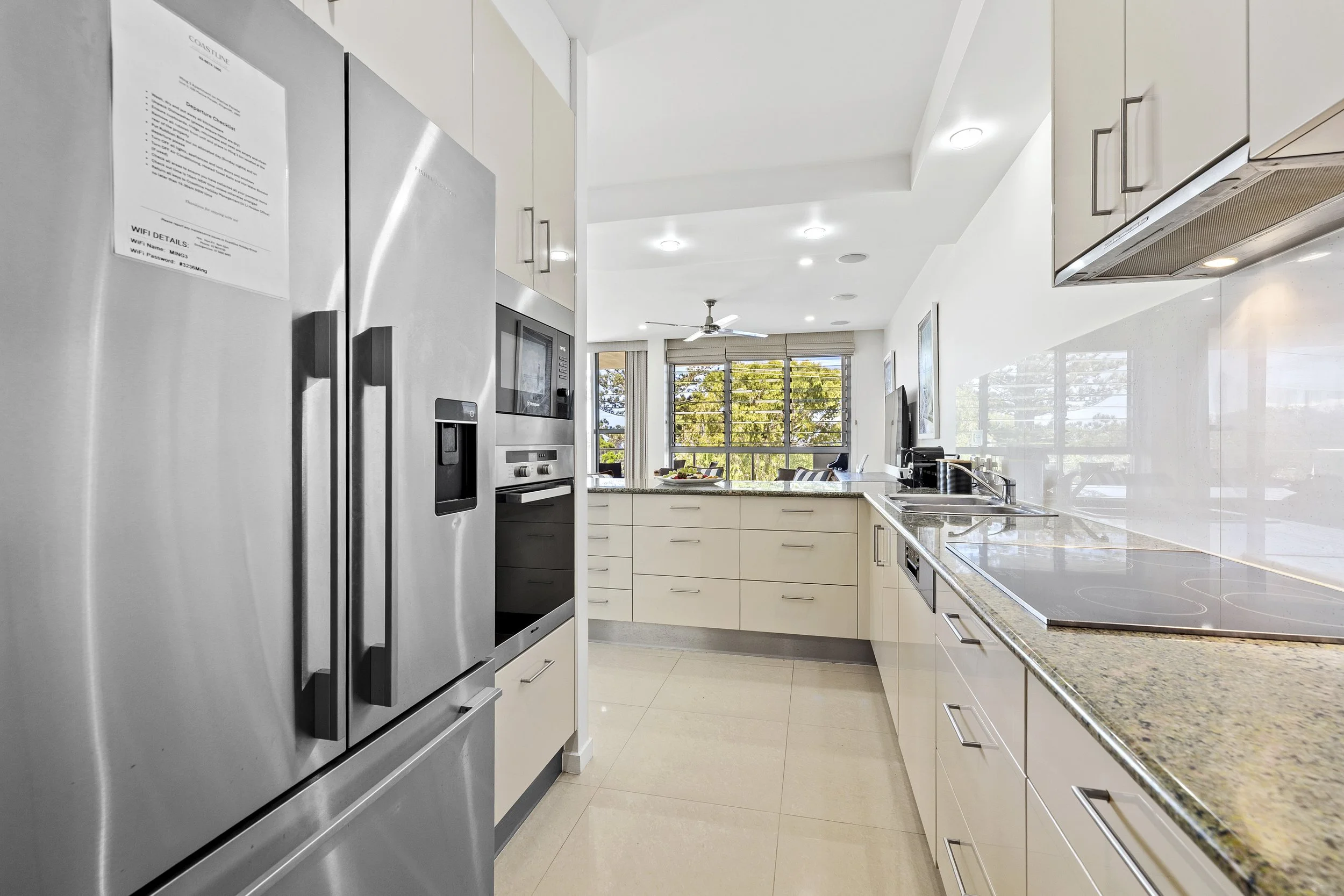 Fully equipped modern kitchen with stone benchtops, a full-size refrigerator and built-in european appliances at MING 3.