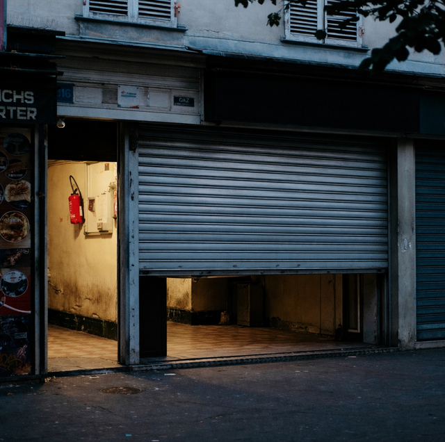 commercial roll-up door partially lowered at dusk storefront