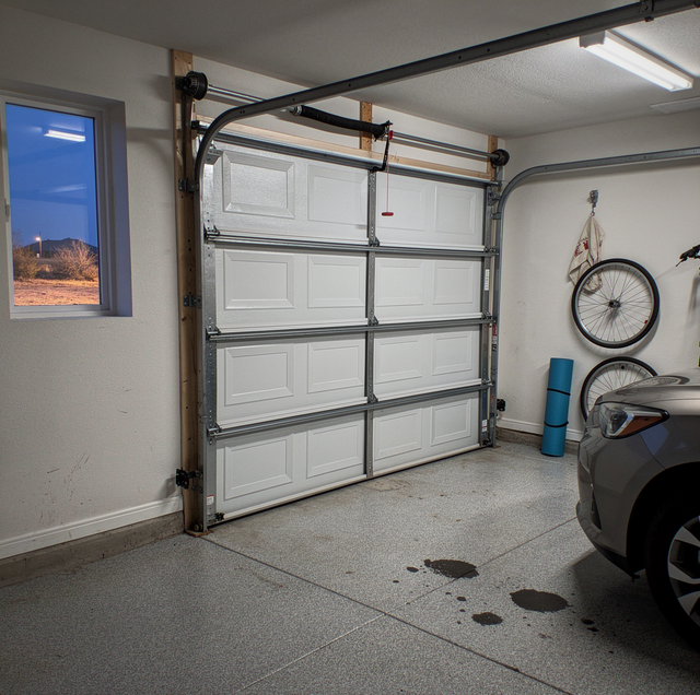 garage door stuck halfway at dark driveway