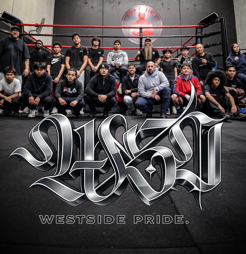 group of diverse young men and boys in a boxing gym, sitting and standing in front of a boxing ring, with a logo that reads "Westside Pride" and "Top King" in the background.