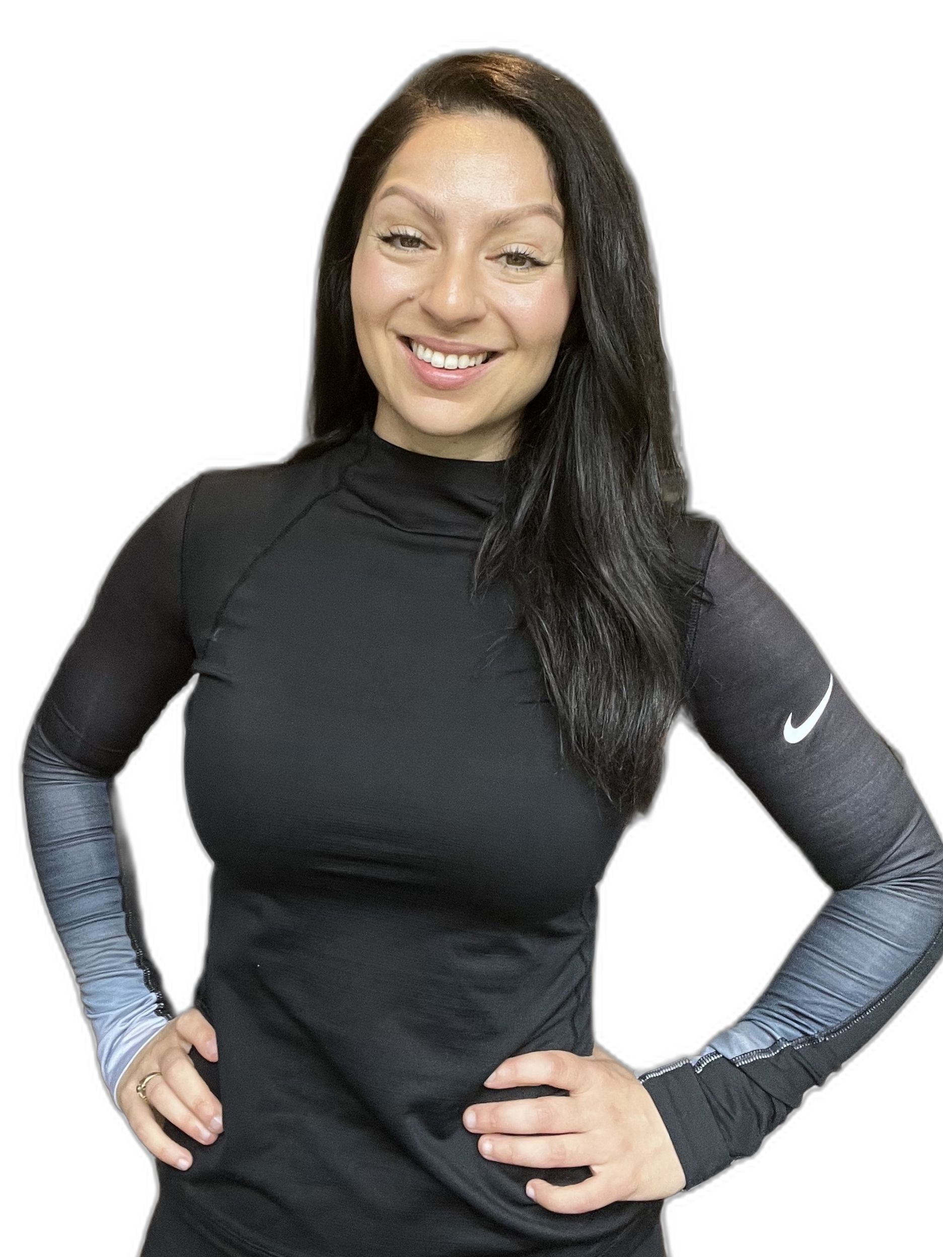En kvinnlig person med långt mörkt hår, leende, klädd i svart sportlinne med Nike-logga på armen, står med händerna på höfterna mot en svart bakgrund.