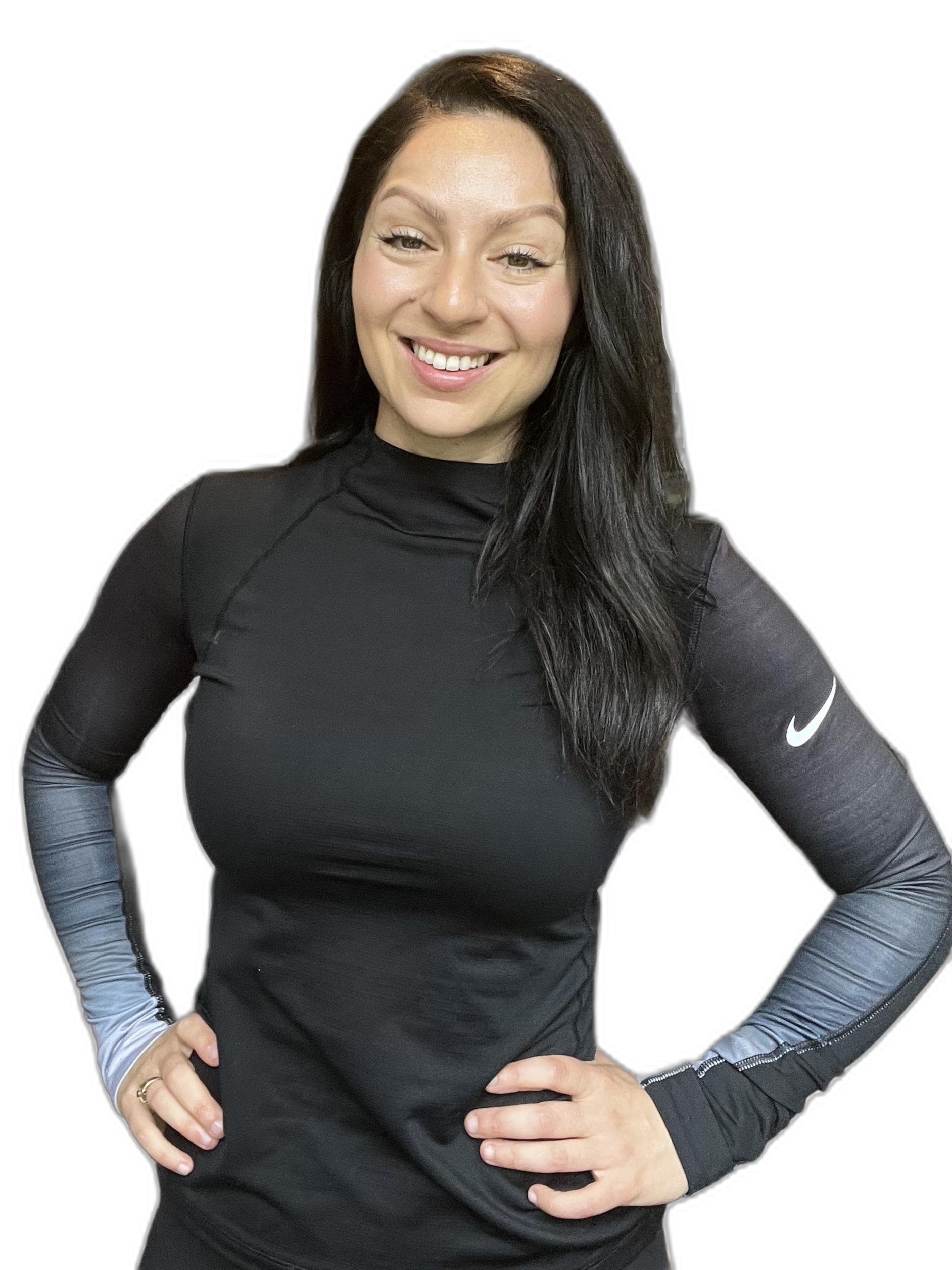 A woman smiling, wearing a long-sleeve athletic shirt with Nike logo, has dark hair, and her hands on her hips, against a black background.