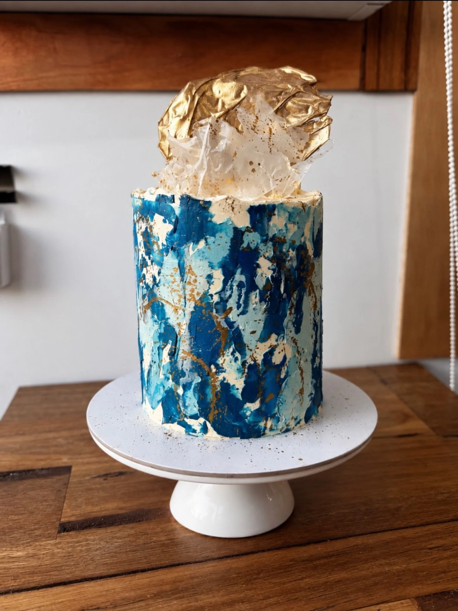 Blue watercolour buttercream cake with gold accents. Modern artistic and available online