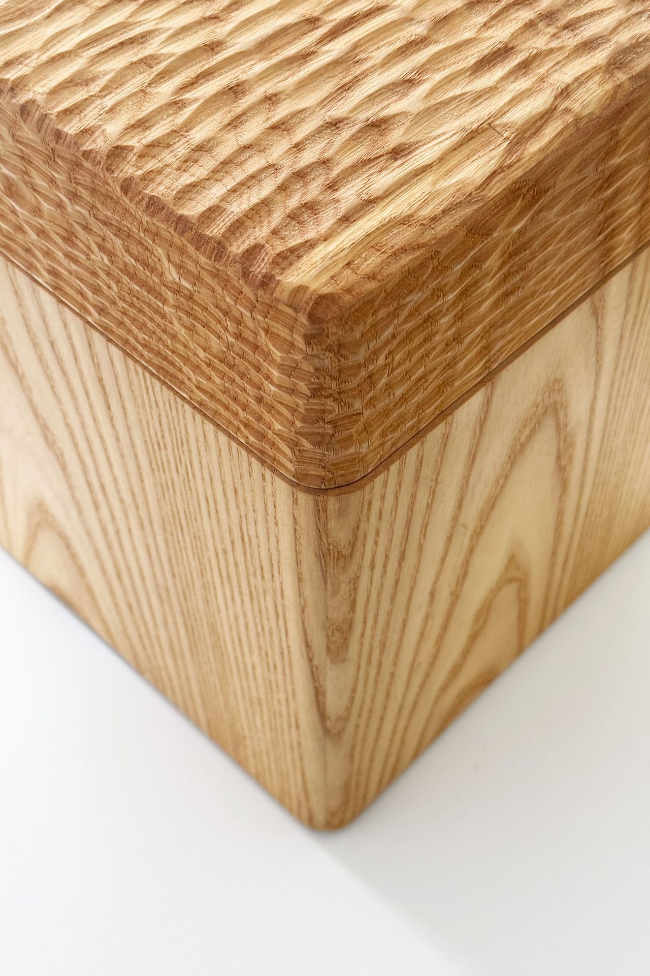 Close-up of a wooden corner table with visible wood grain and beveled edges