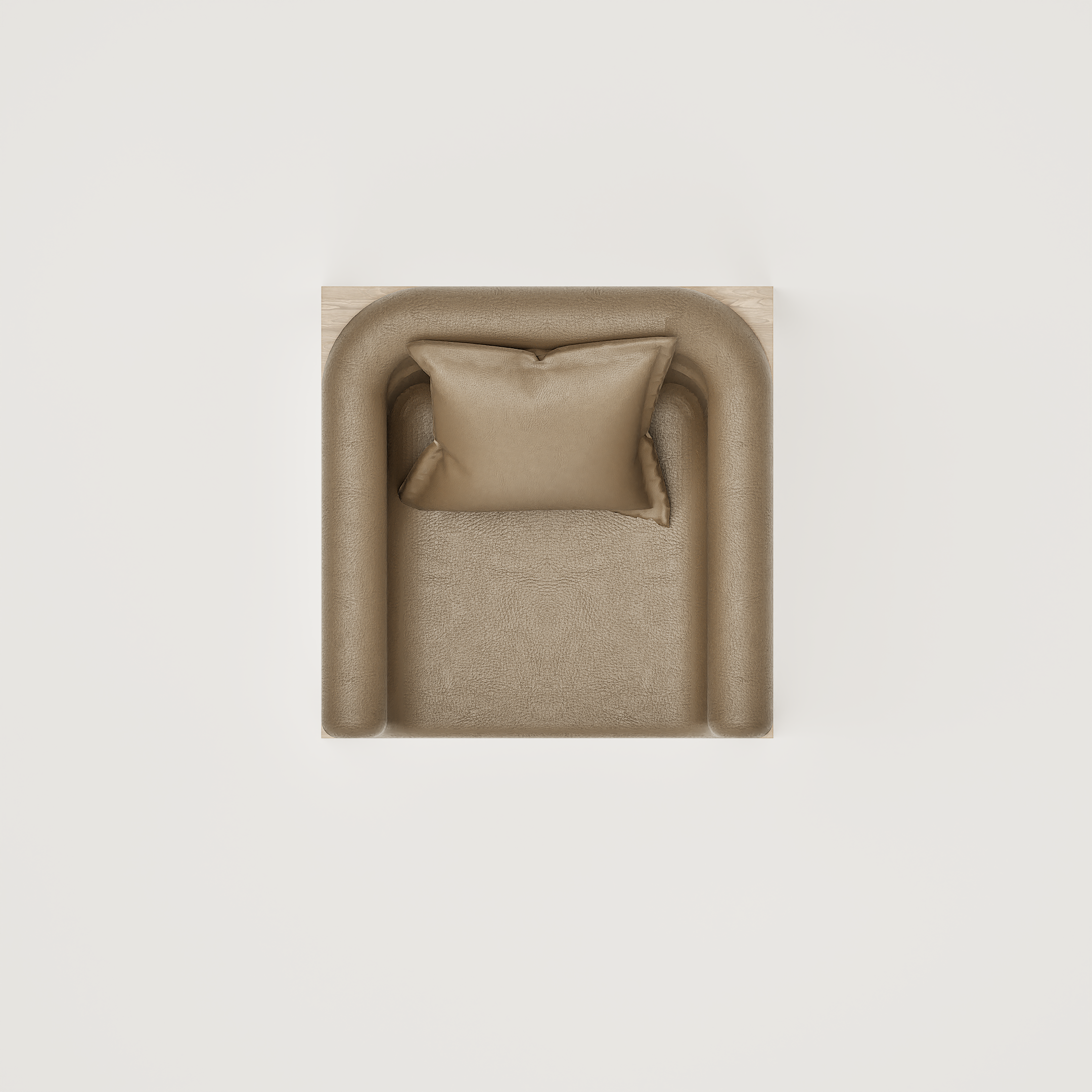 Vue aérienne d'un fauteuil en cuir beige avec coussin, placé sur un sol en bois clair, contre un mur blanc
