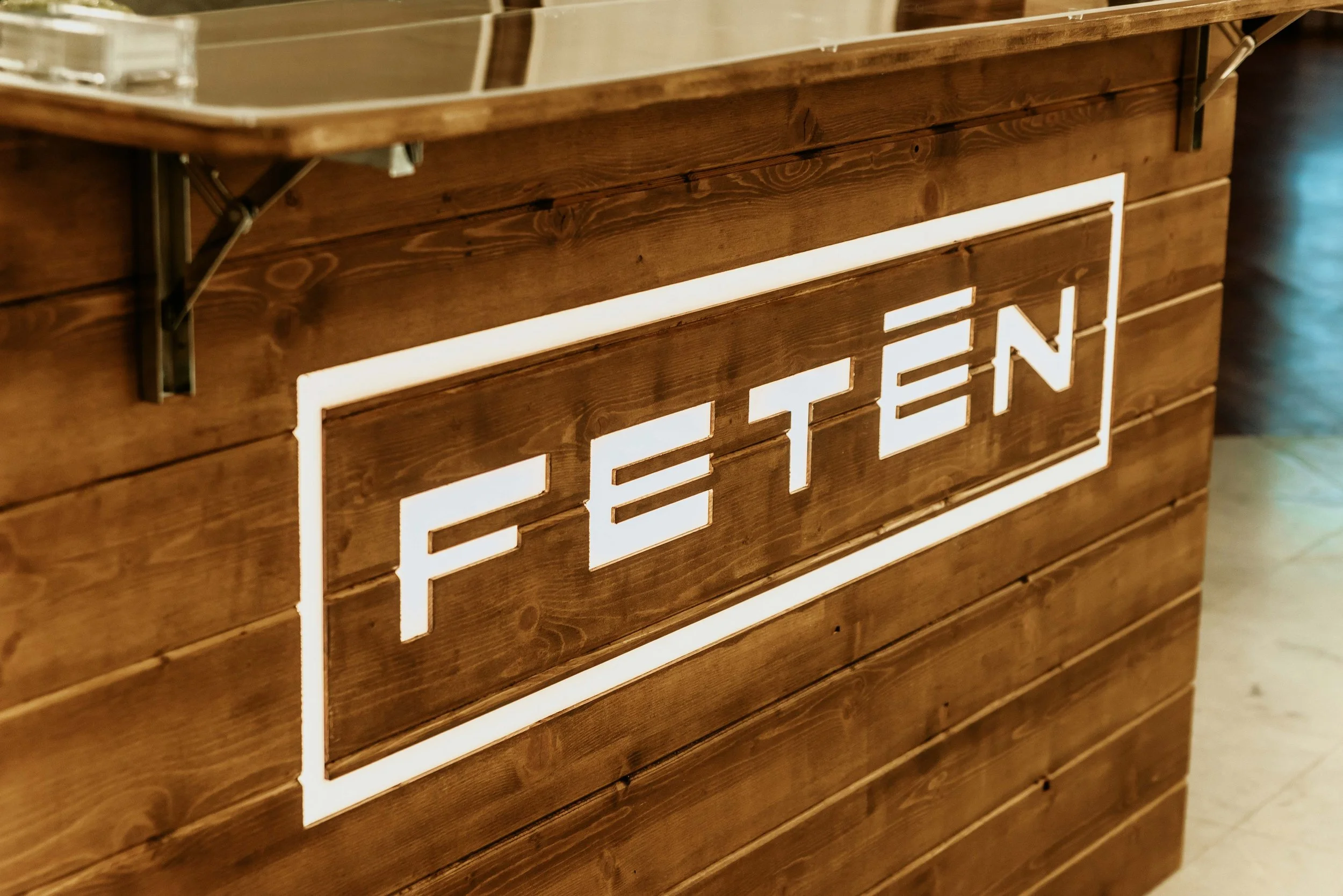 Mueble de madera con una señal de neón que dice 'EATEN'.