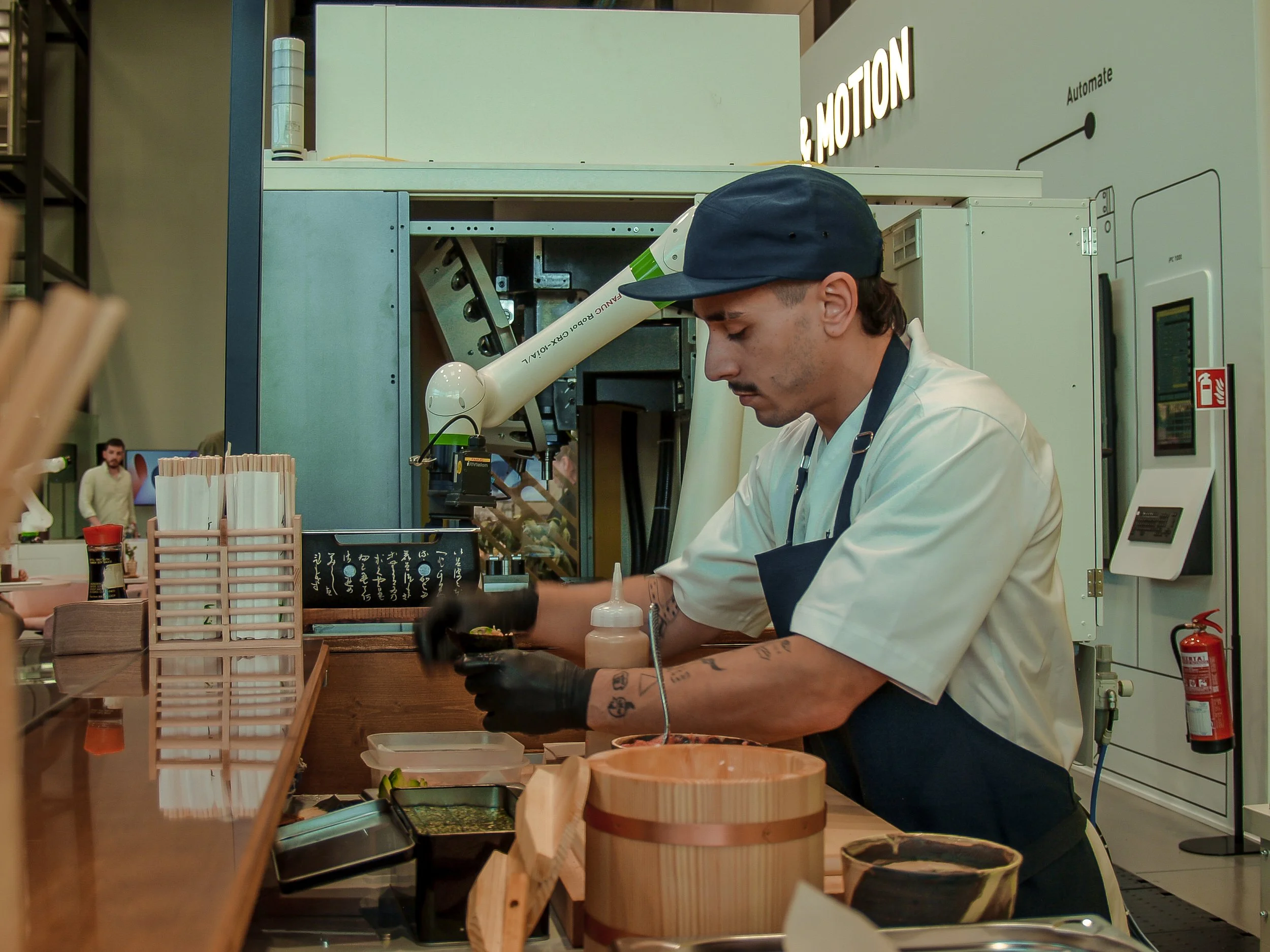 Hombre sirviendo comida en un restaurante de estilo japonés con un ambiente moderno.