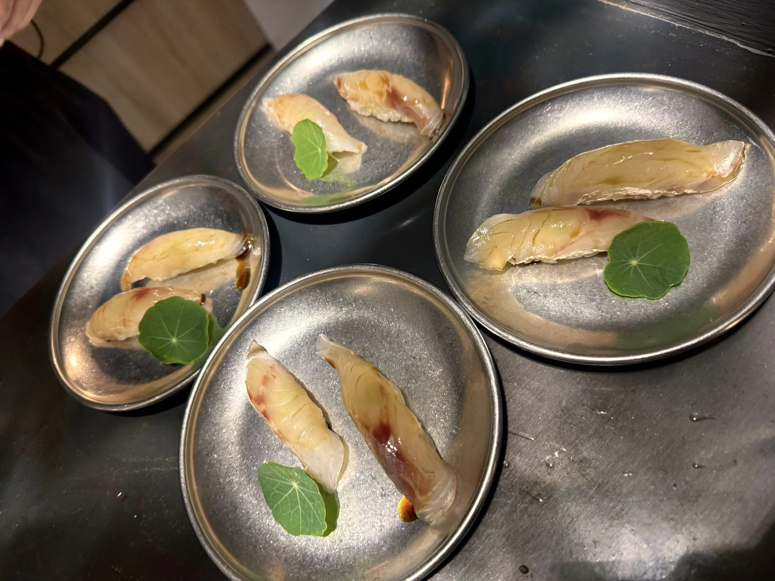 Carnes blancas en latas con hojas verdes decorativas