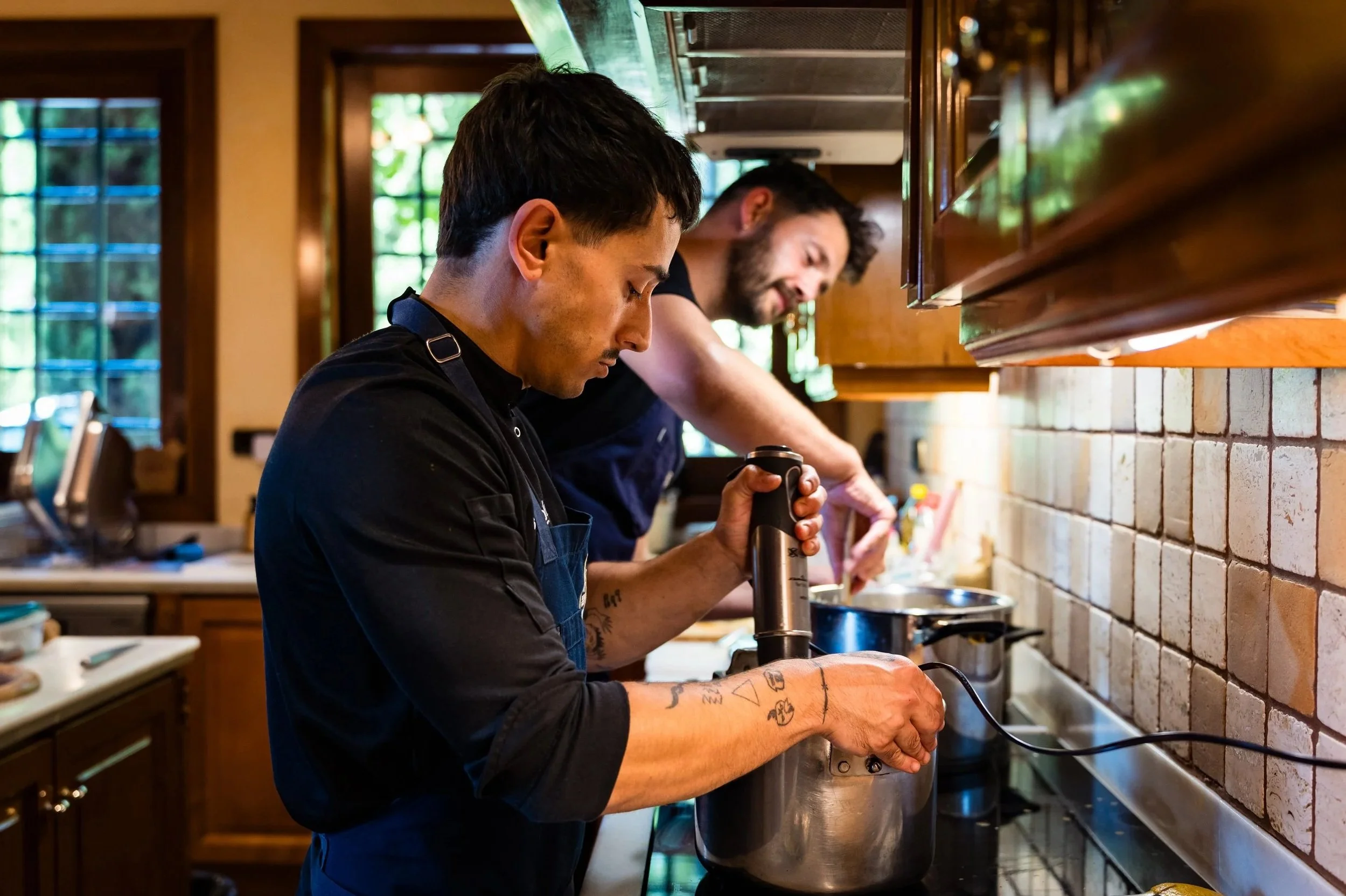 Dos hombres cocineros preparando comida en una cocina de restaurante.