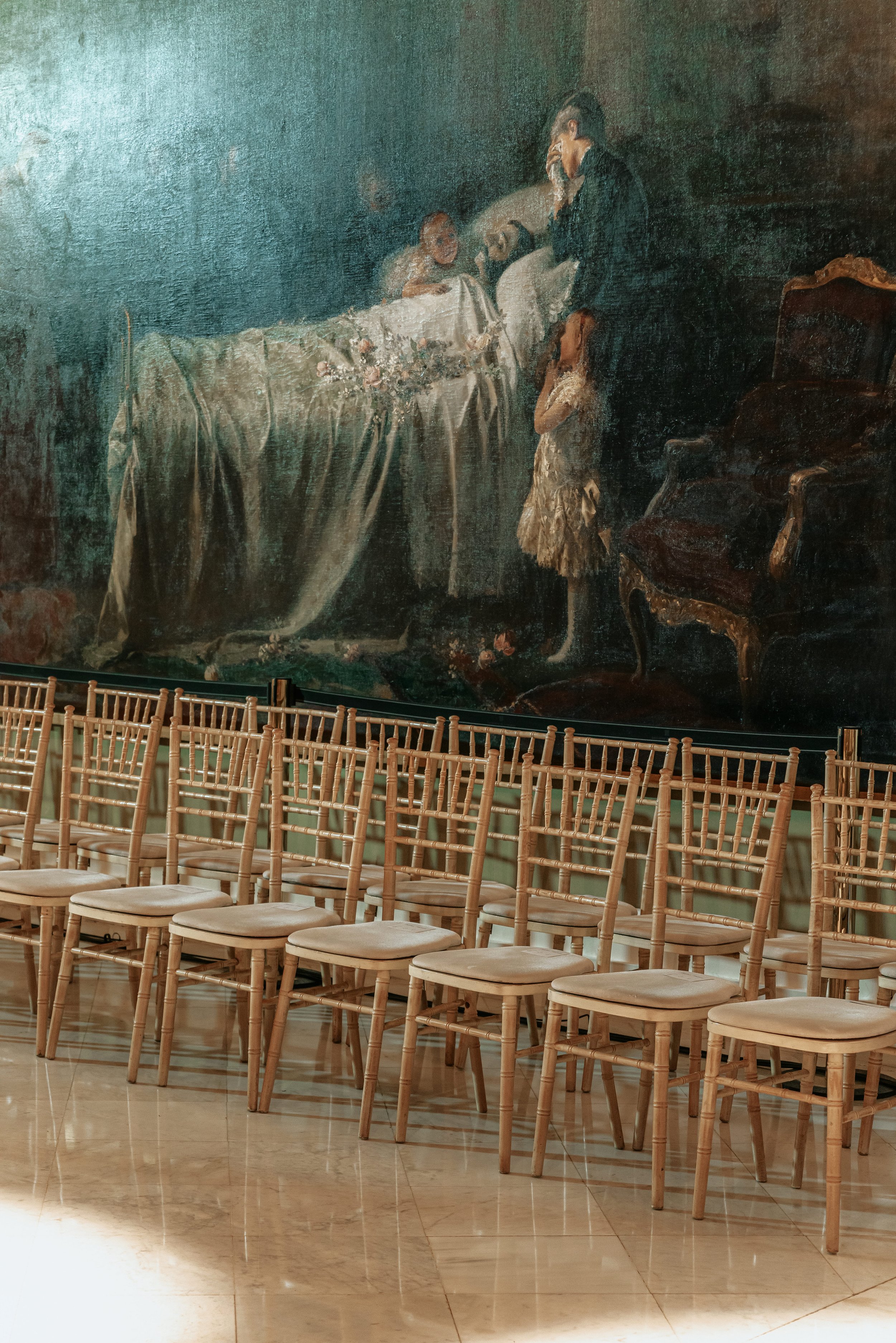 Cuadros en la pared y sillas de madera en una sala de eventos o iglesia. Palacio de Pedralbes.