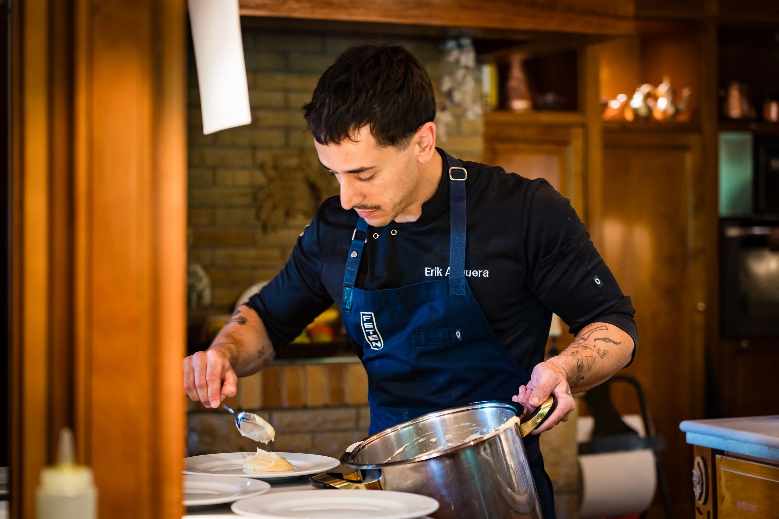 Hombre cocinando en la cocina, sirviendo comida en un plato.