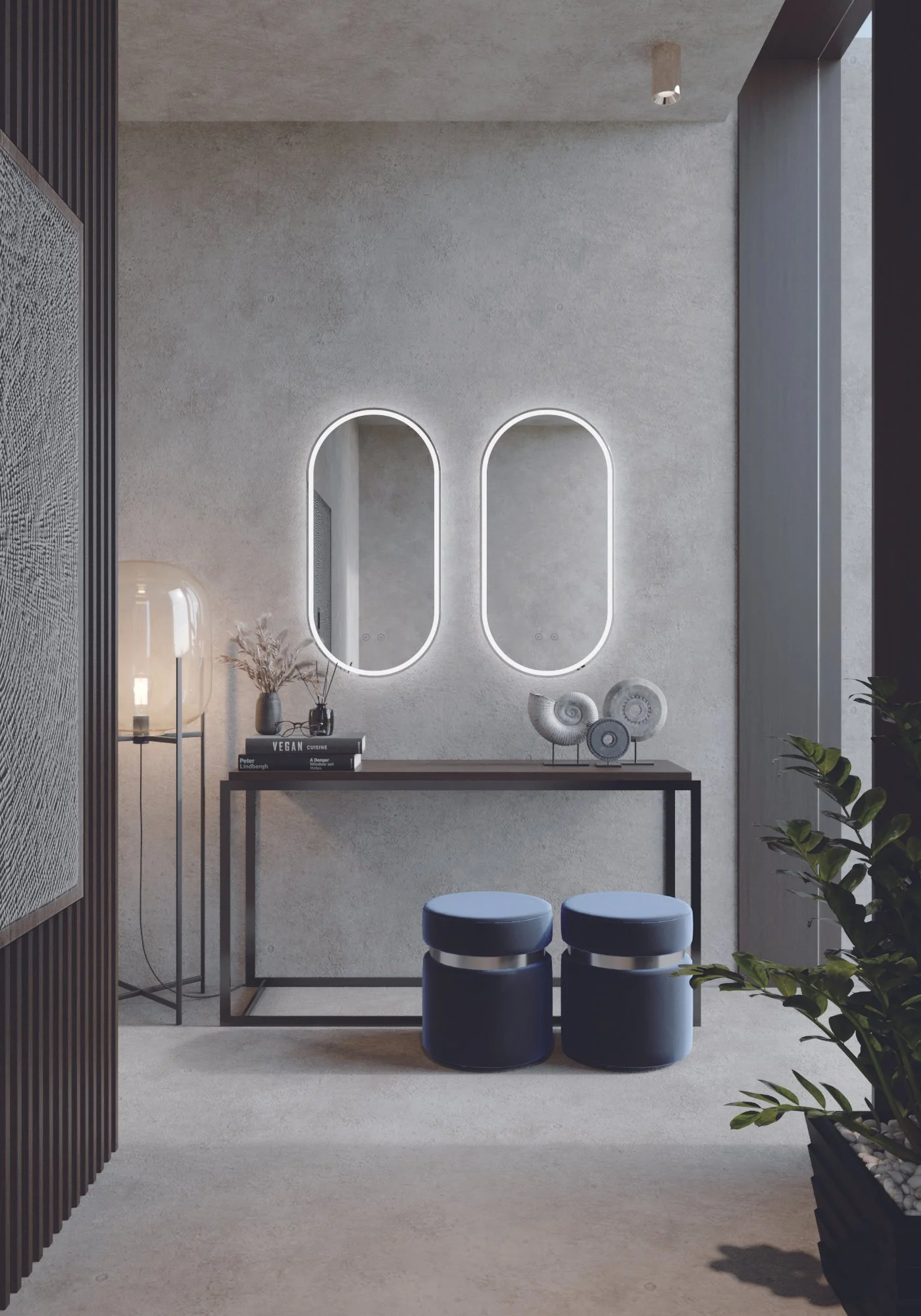 Modern minimalist interior with two oval illuminated mirrors on a textured grey wall, a black console table holding decorative shells, books, and a vase with dried branches, flanked by two navy blue stools, adjacent to a wooden slatted partition and potted plants.
