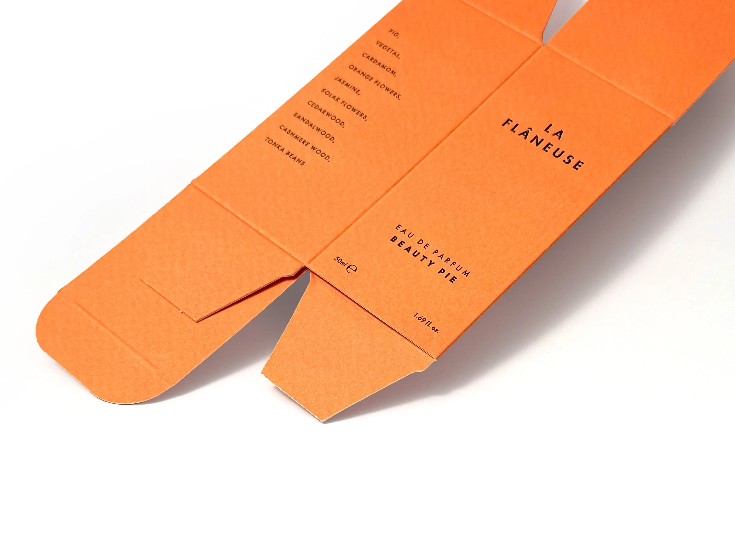 Orange packaging with black text listing fragrance notes. Beauty Pie produced by Windles Packaging.