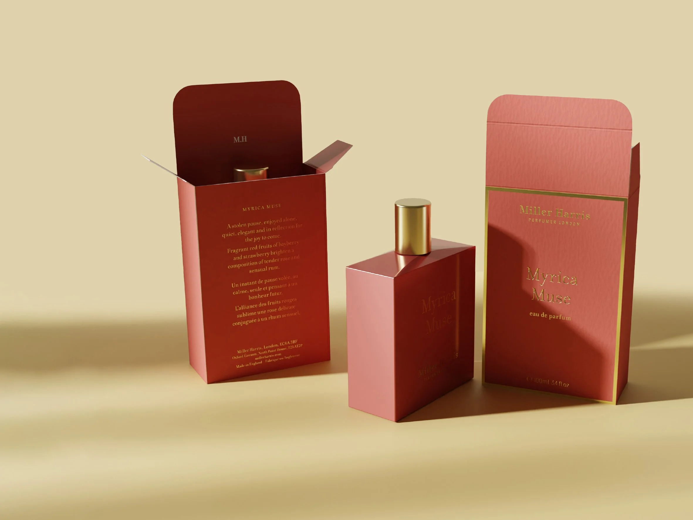 Three perfume bottles and their boxes on a beige background. The boxes are pink and red with gold lettering, and the bottles are gold and pink. Carton packaging produced by Windles Packaging.