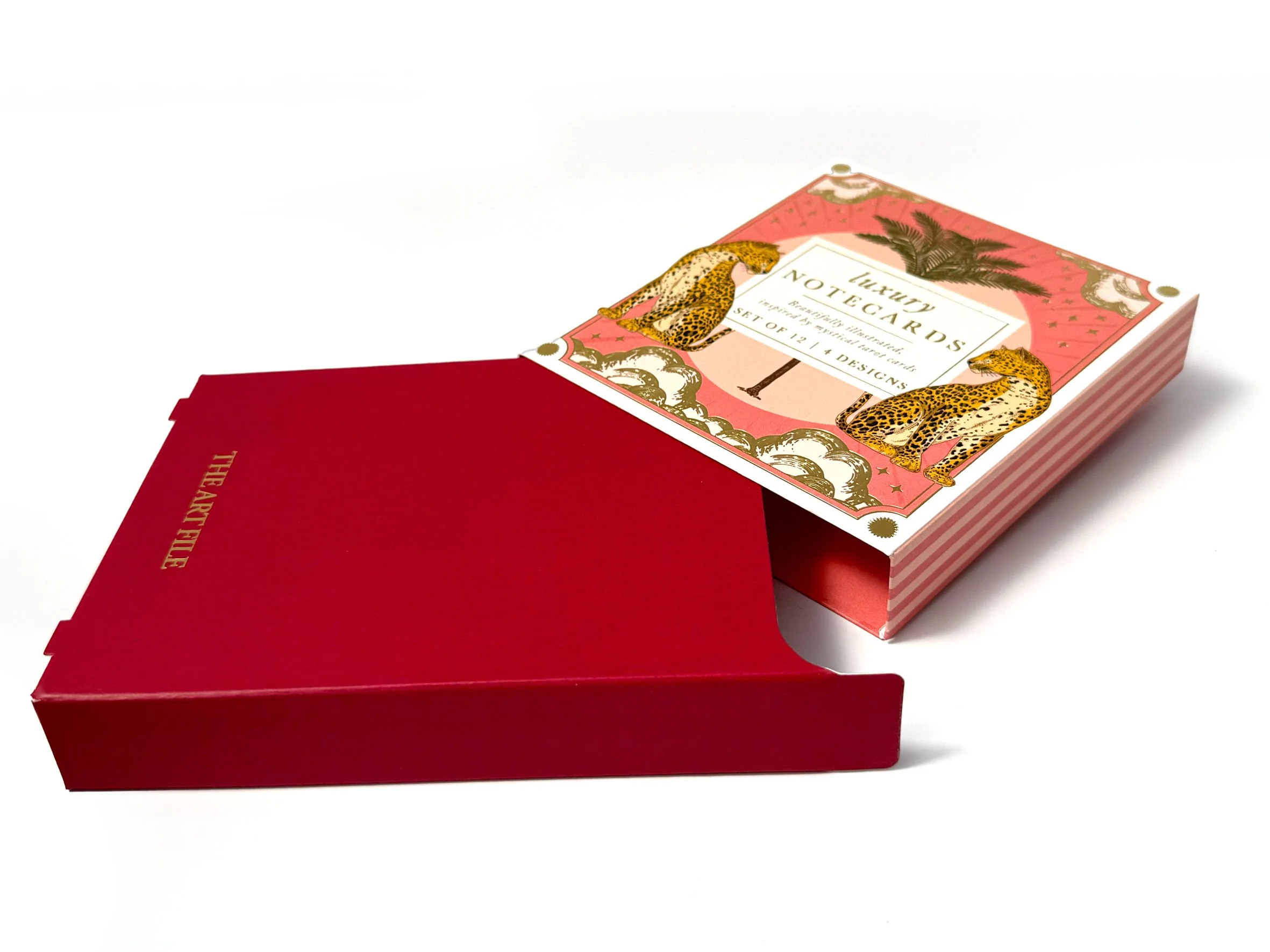 Close-up of a box of luxury notecards with decorative leopard illustrations and a red recipe box underneath. Carton packaging produced by Windles Packaging.