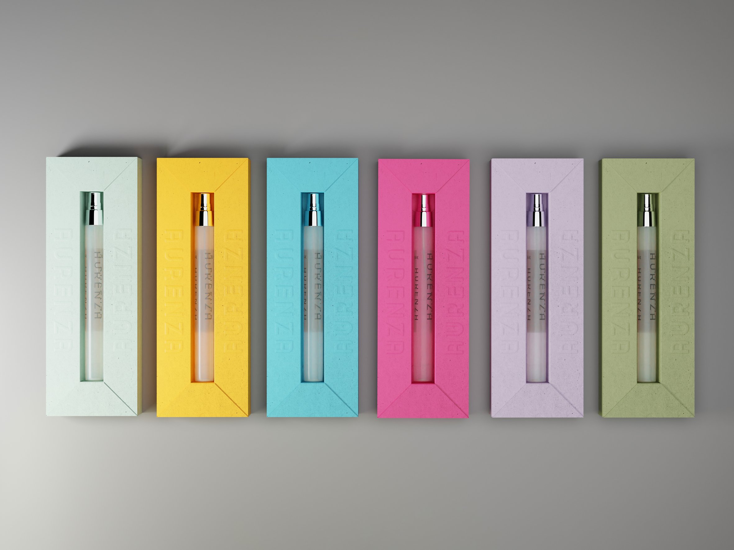 Six colorful rectangular boxes with perfume bottles inside, arranged in a row on a grey surface. Carton packaging produced by Windles Packaging.