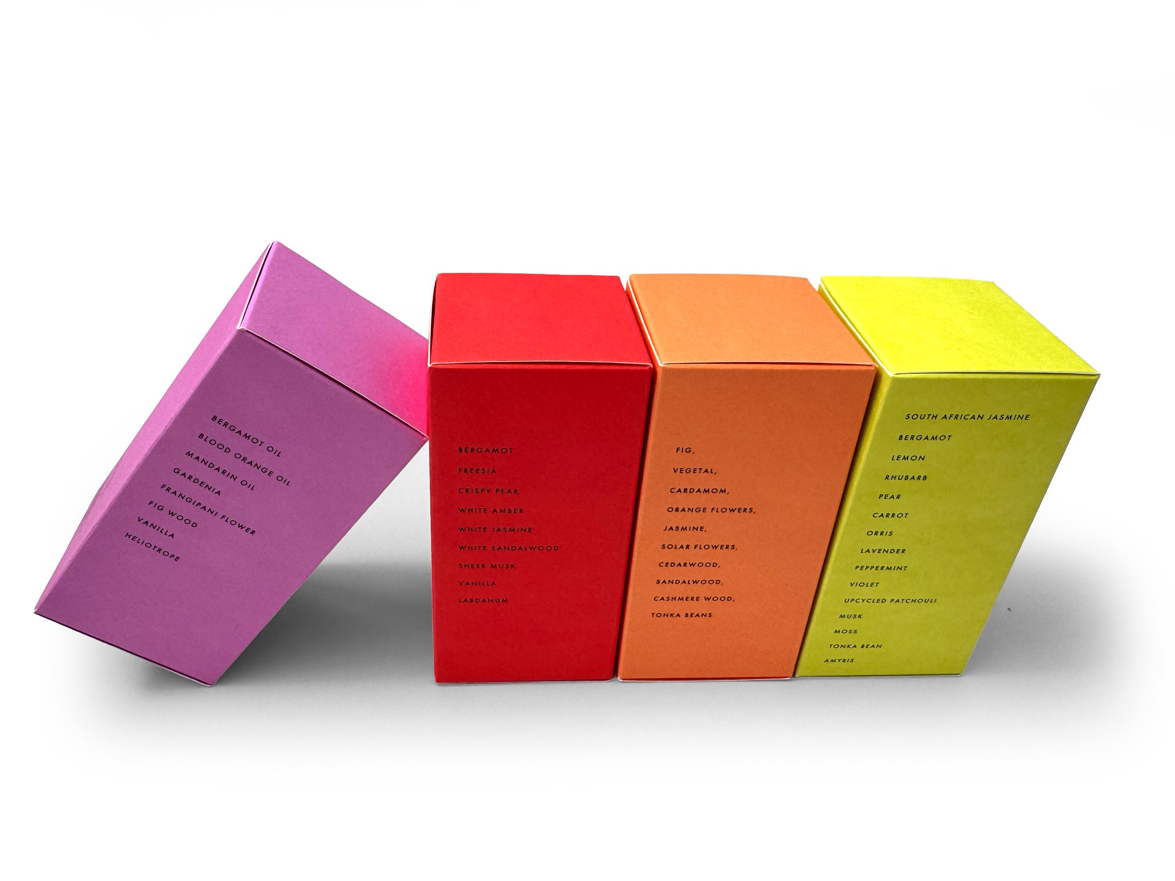 Four colorful boxes, pink, red, orange, and yellow, arranged in a row, with visible lists of scent notes and descriptions on the side.