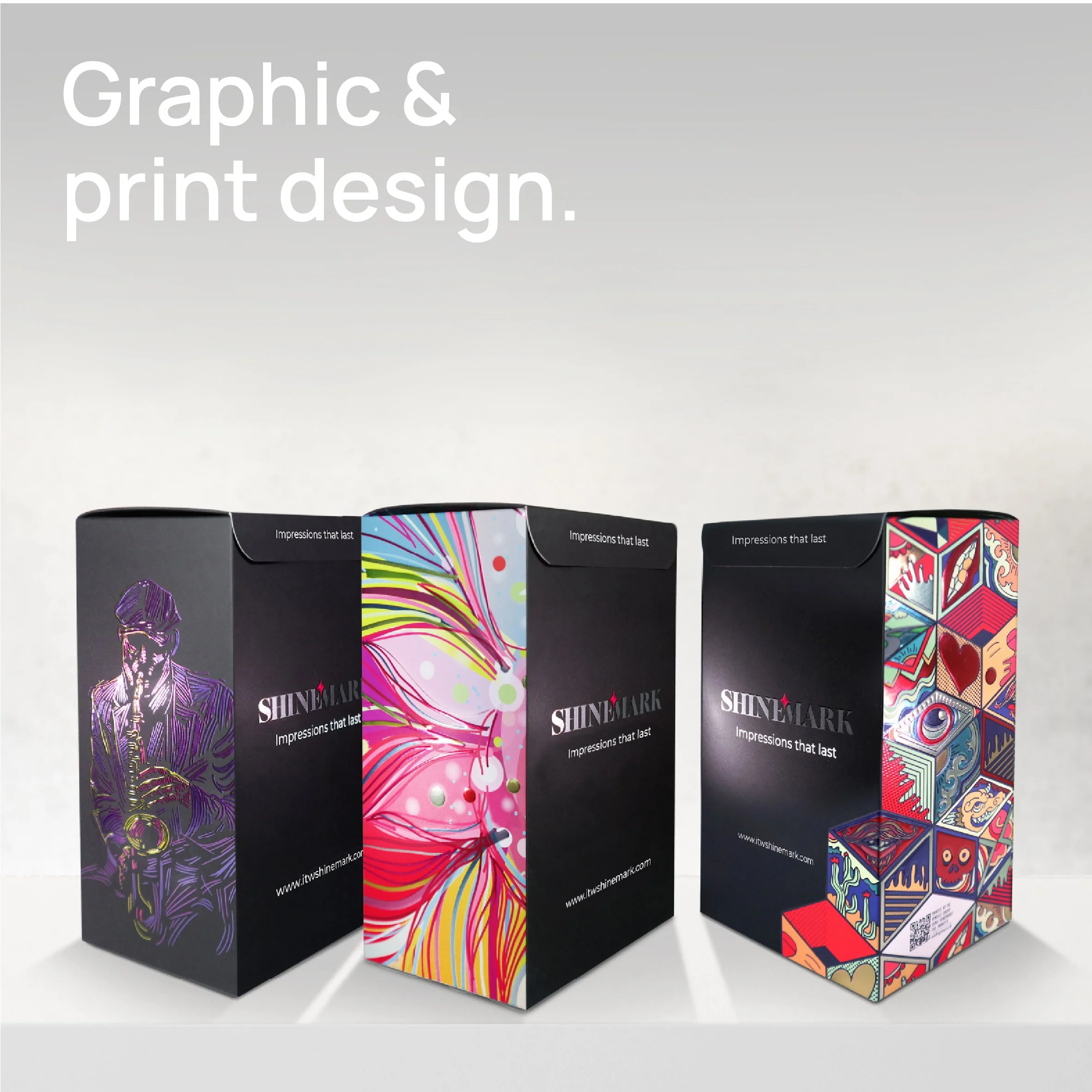 Three colorful boxes with graphic and print designs are displayed on a white surface.