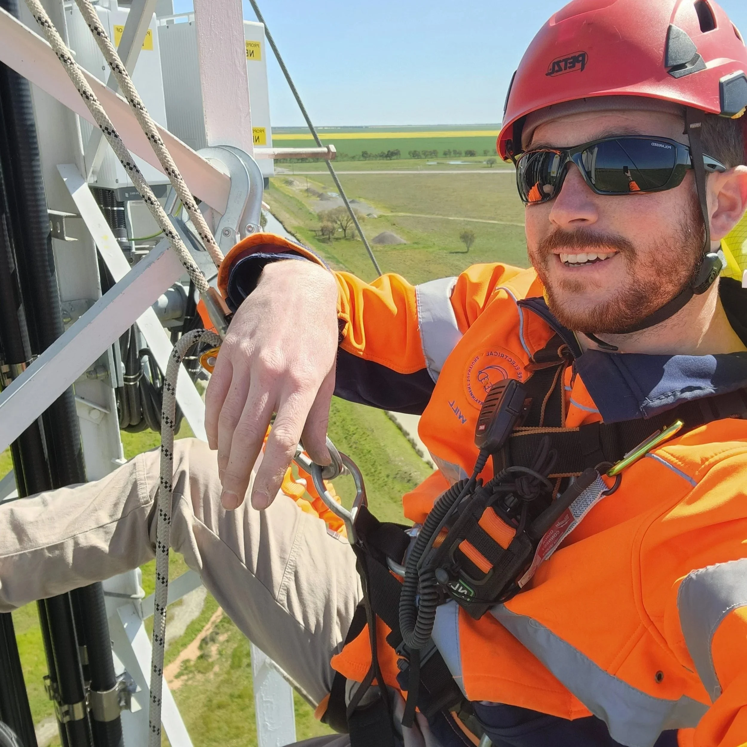The boss wearing high vis clothing and safety harness equipment while working on a telecommunications tower in regional NSW