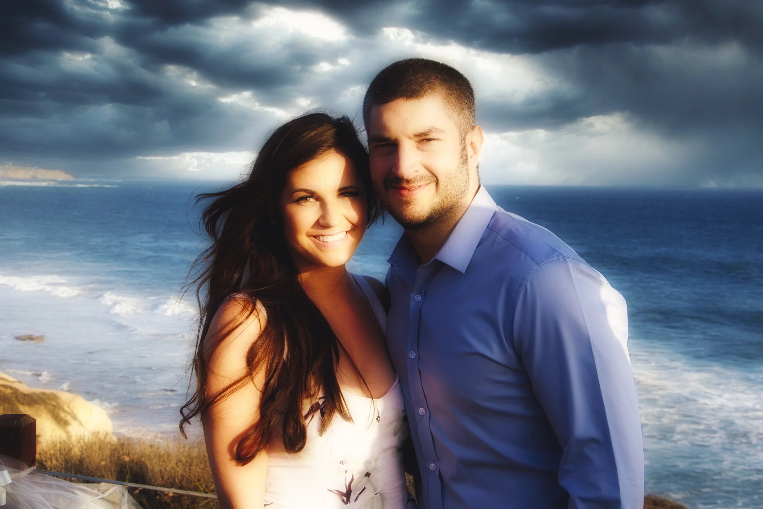 A couple attending an Event at Chrystal Cove along Pacific Coast Hi-way in Orange County California.  A soft focus  portrait with the Pacific Ocean in the background.  Photo taken approx. 2012.