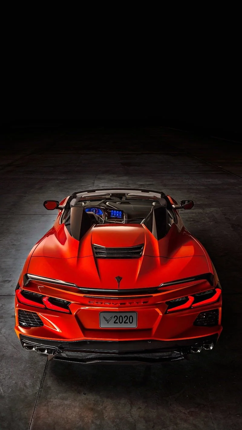 Red 2020 Chevrolet Corvette convertible sports car shown from a front overhead angle, parked on a dark concrete surface.