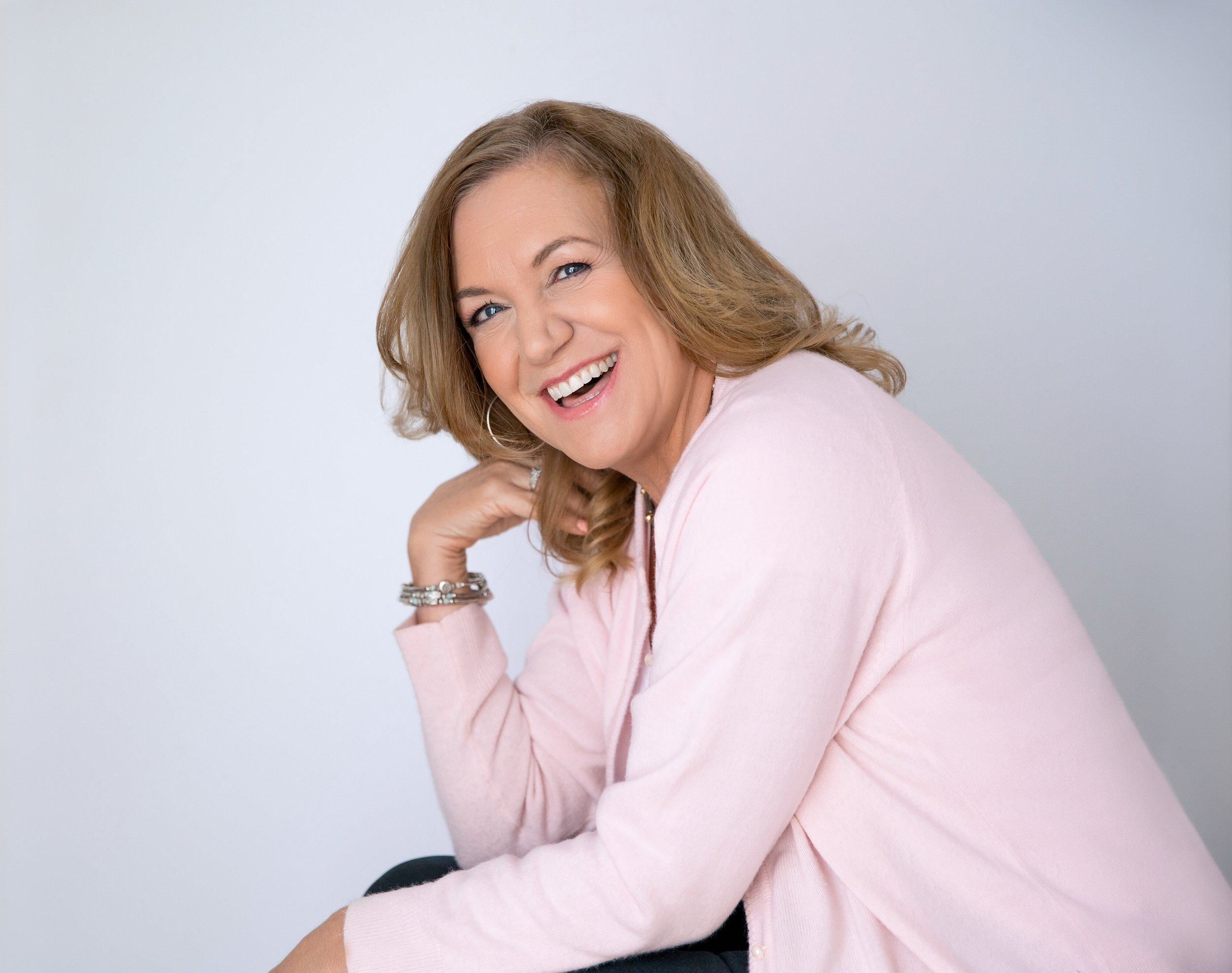 Mature woman laughing pink sweater