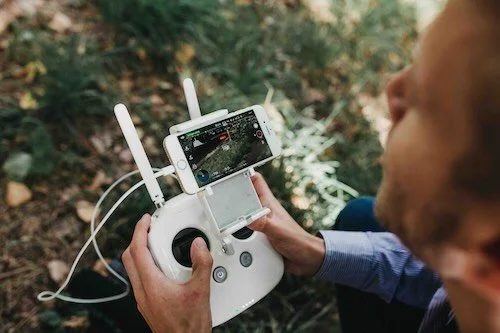 Man houdt een monitor van een DJI drone vast en bekijk de dronebeelden